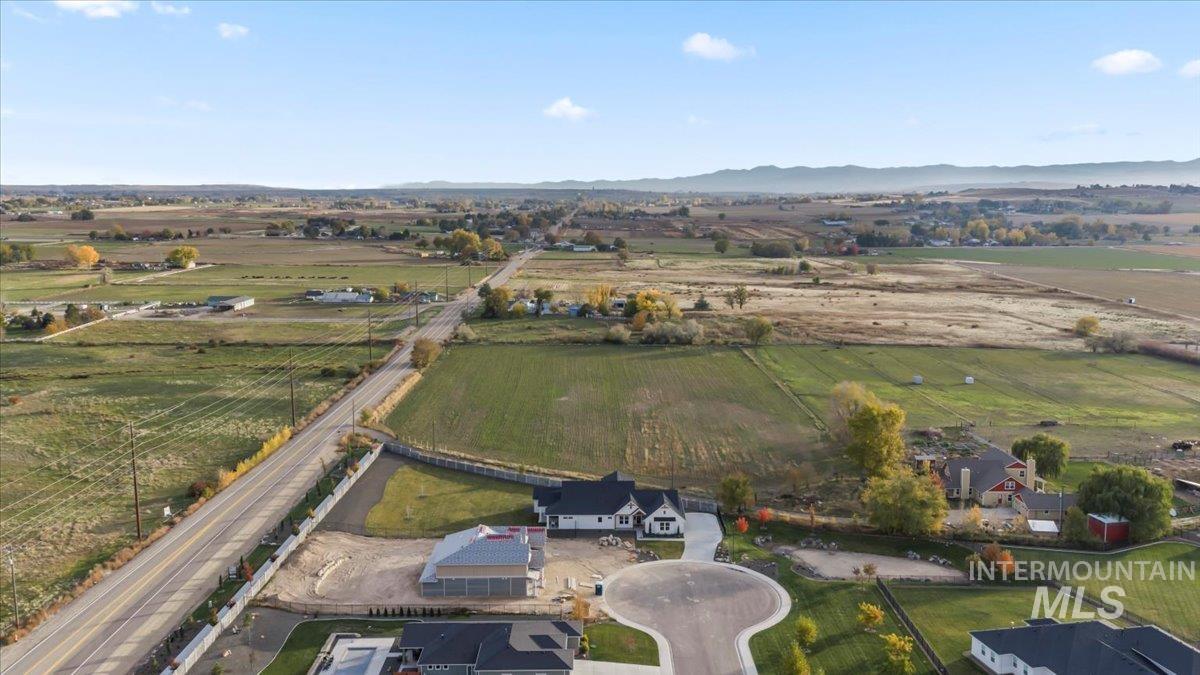 Aerial view of property's location with rural landscape and a mountain backdrop