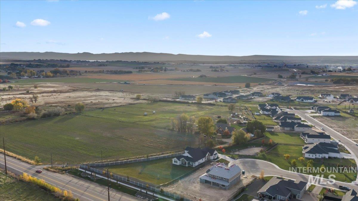 Aerial overview of property's location featuring rural landscape and a mountainous background