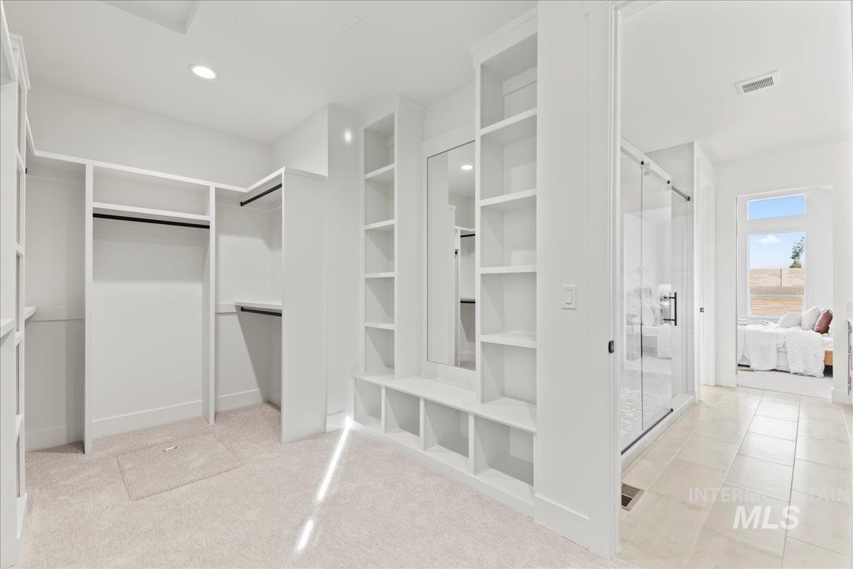 Spacious closet with light carpet