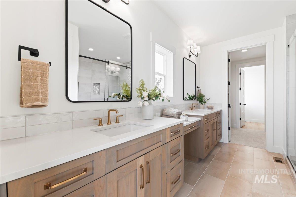 Bathroom with a shower stall, two vanities, light tile patterned flooring, and recessed lighting