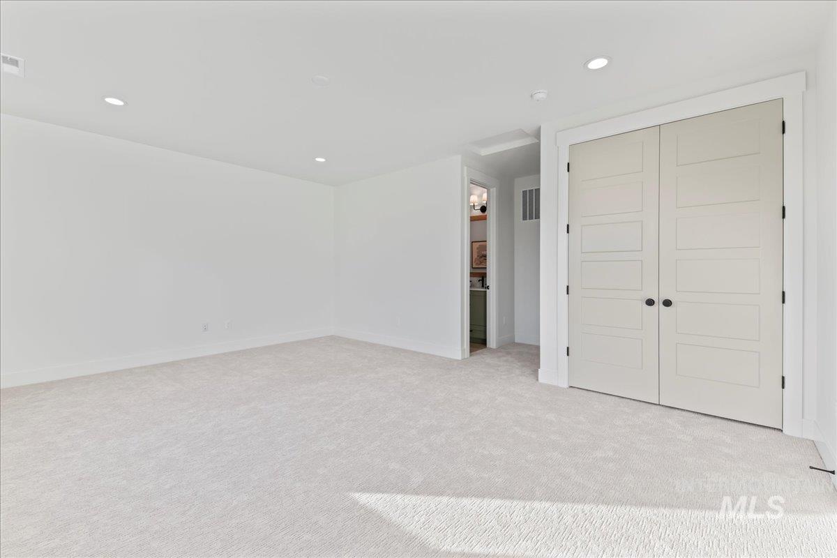 Unfurnished bedroom featuring recessed lighting, light carpet, and a closet