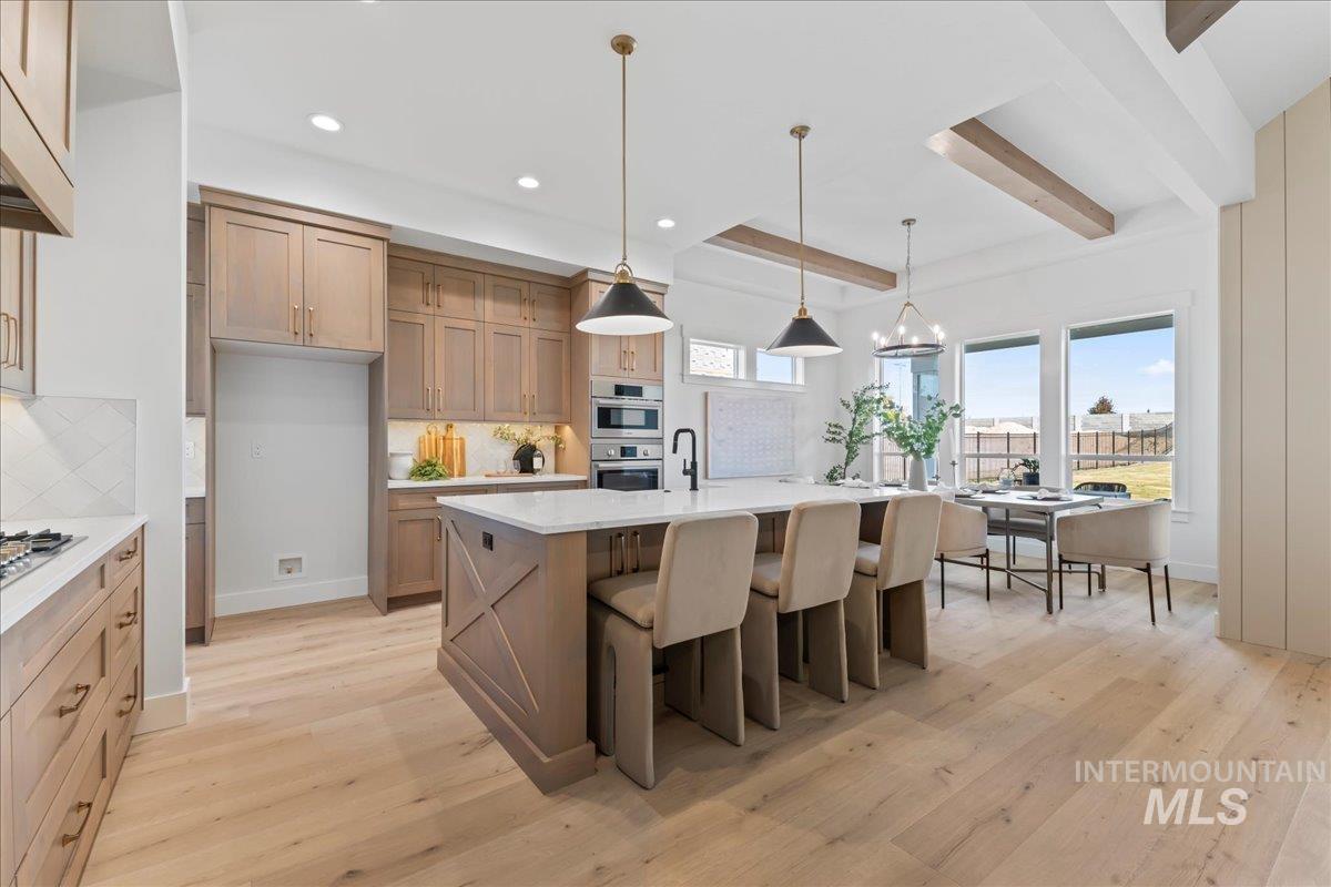 Kitchen featuring beam ceiling, hanging light fixtures, light wood-type flooring, decorative backsplash, and recessed lighting