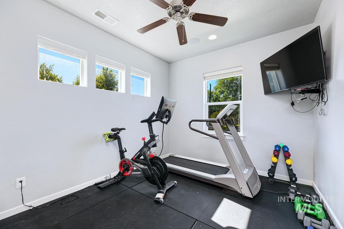 Exercise room with a ceiling fan and recessed lighting