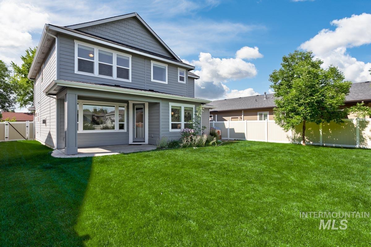 Rear view of house with a fenced backyard, a patio, and a gate