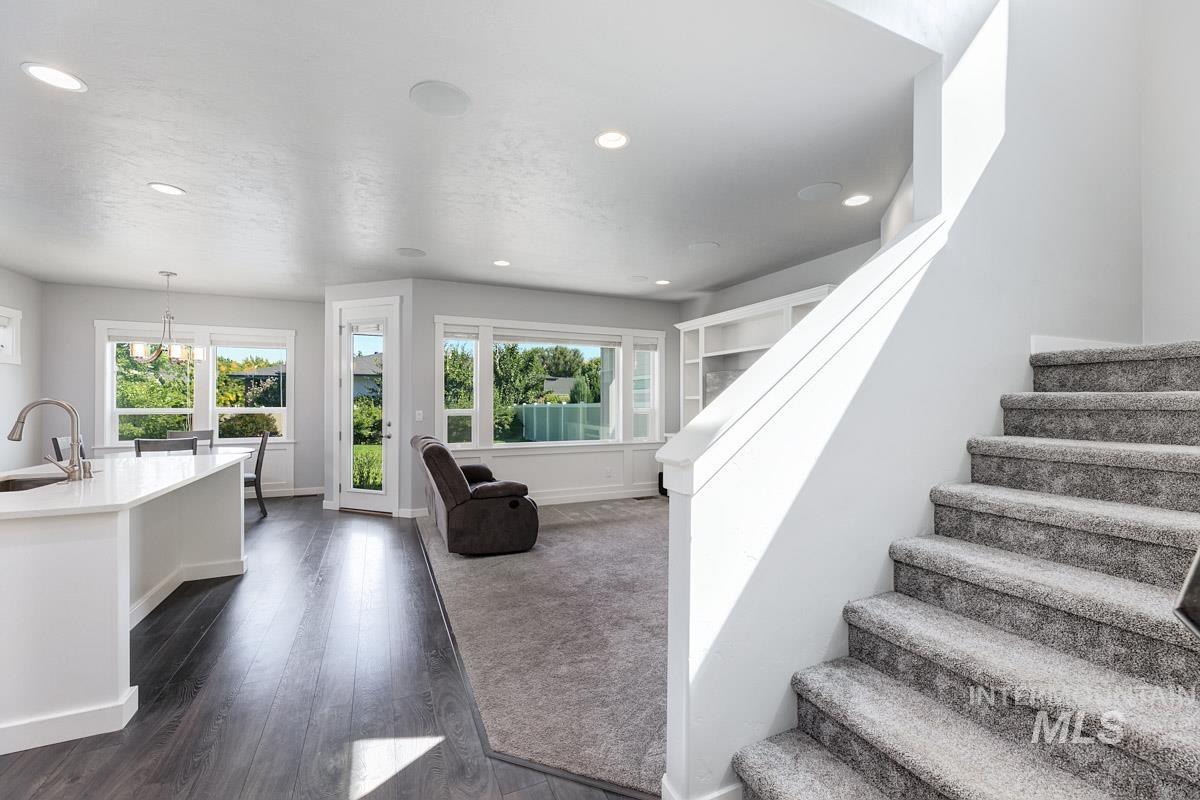 Stairway featuring plenty of natural light, wood finished floors, recessed lighting, and a chandelier