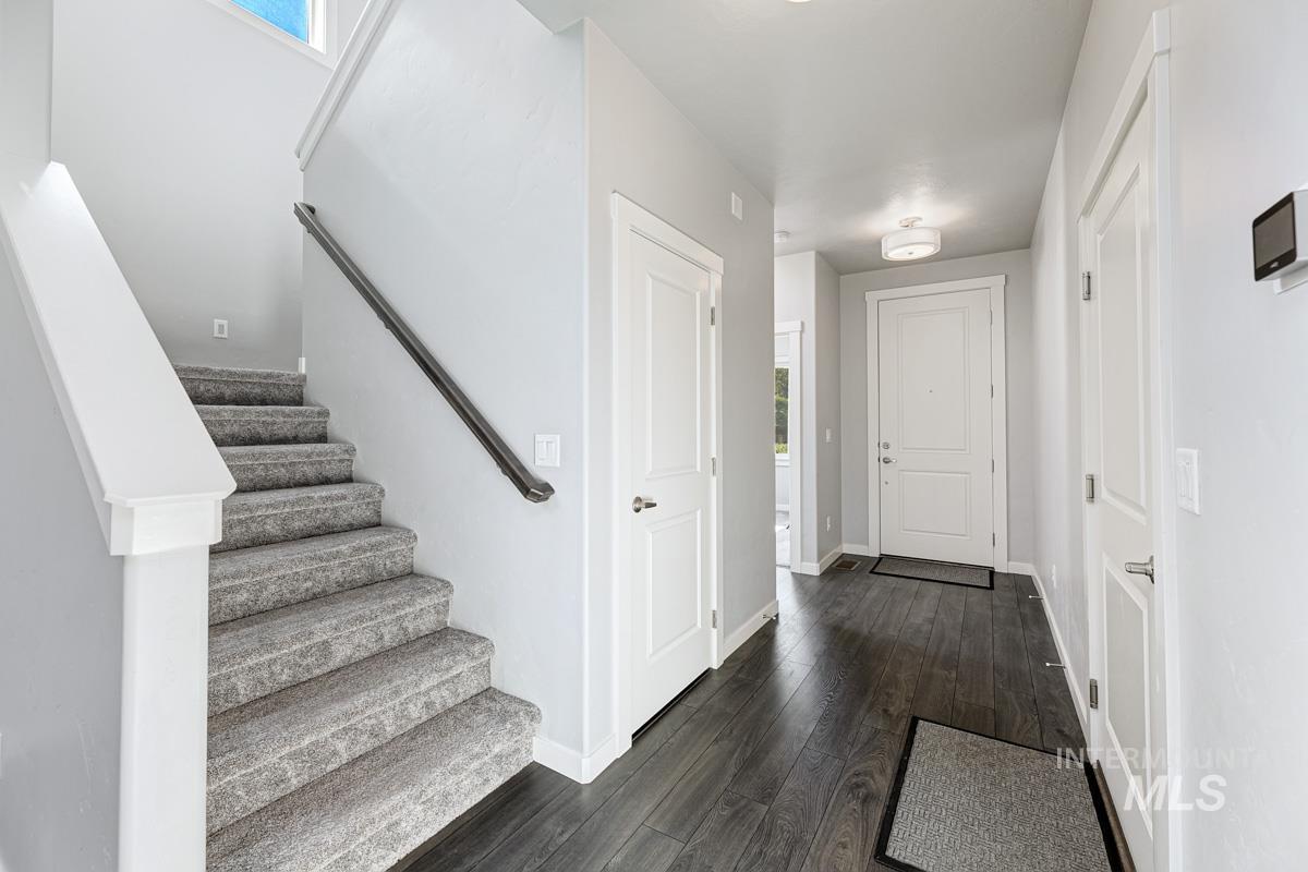 Foyer entrance featuring healthy amount of natural light, dark wood finished floors, and stairway