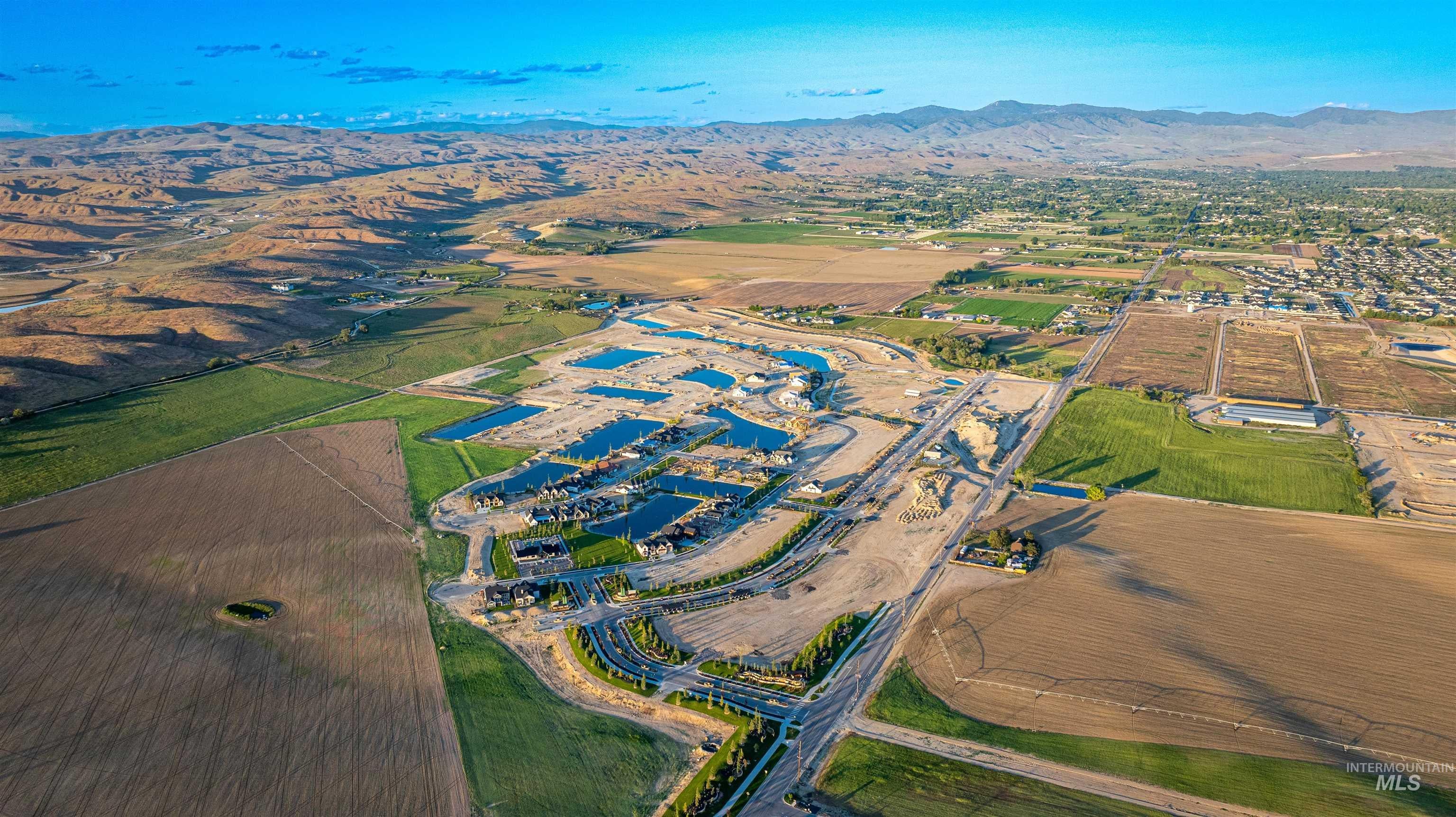Aerial view of property and surrounding area featuring mountains and rural landscape