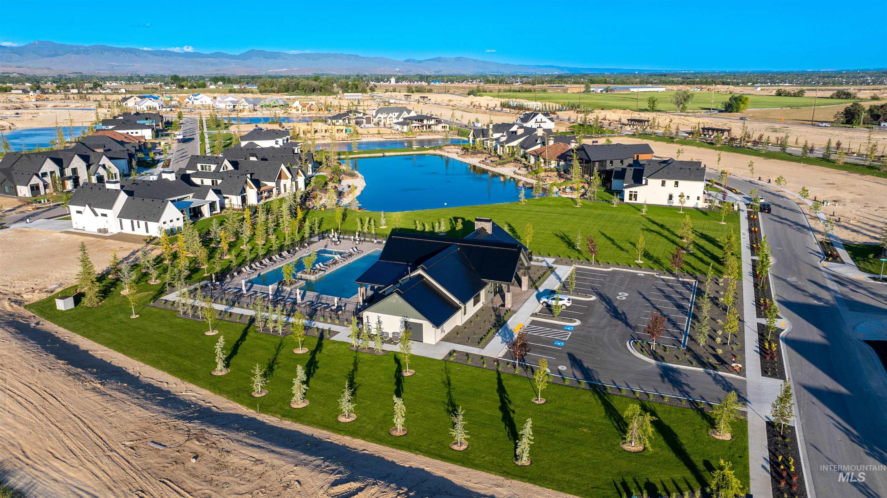 Aerial view of property and surrounding area featuring a water and mountain view and nearby suburban area