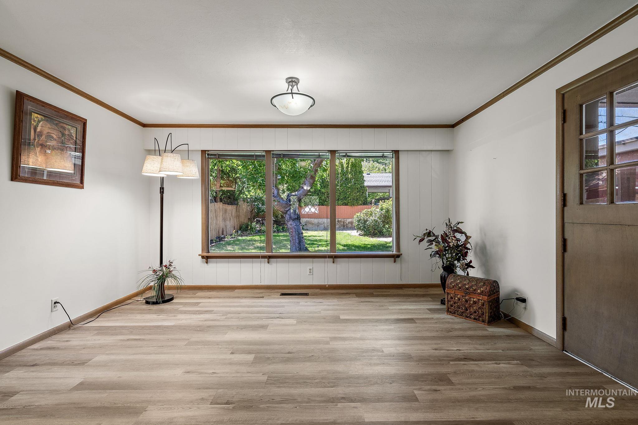 Unfurnished room featuring ornamental molding and wood finished floors