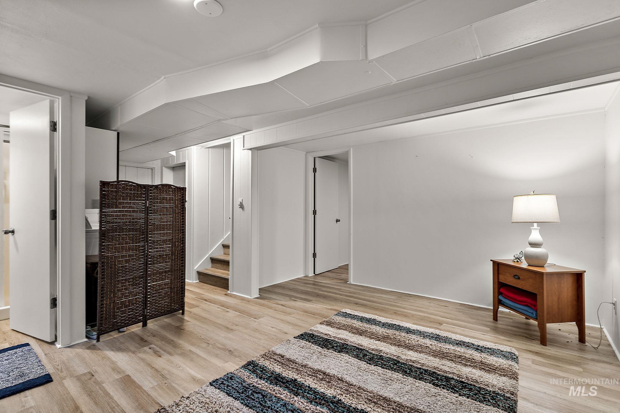 Living area with light wood-style floors and stairway