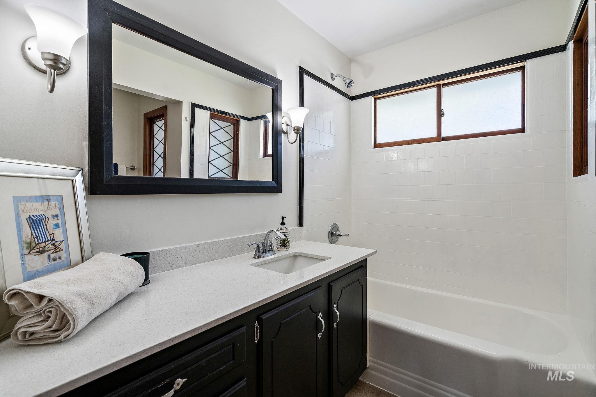 Full bathroom with vanity and washtub / shower combination