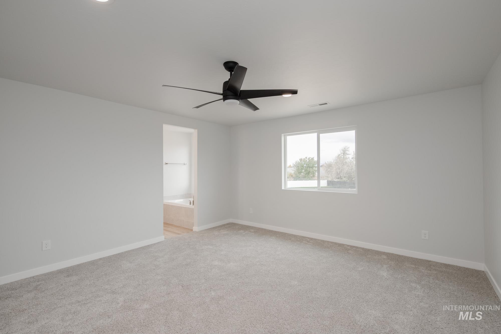 Unfurnished room featuring light carpet and a ceiling fan