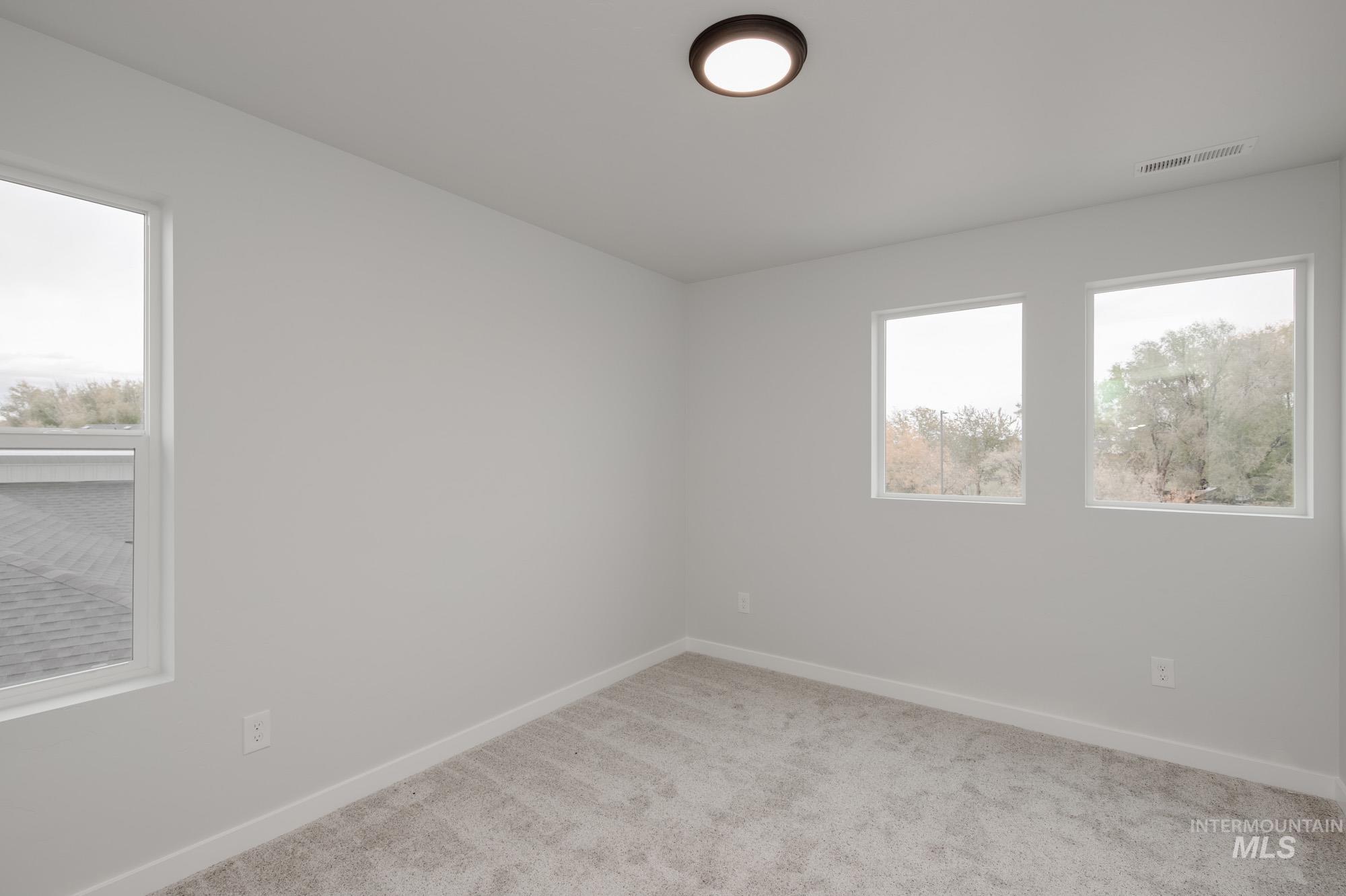 Empty room featuring carpet floors and baseboards