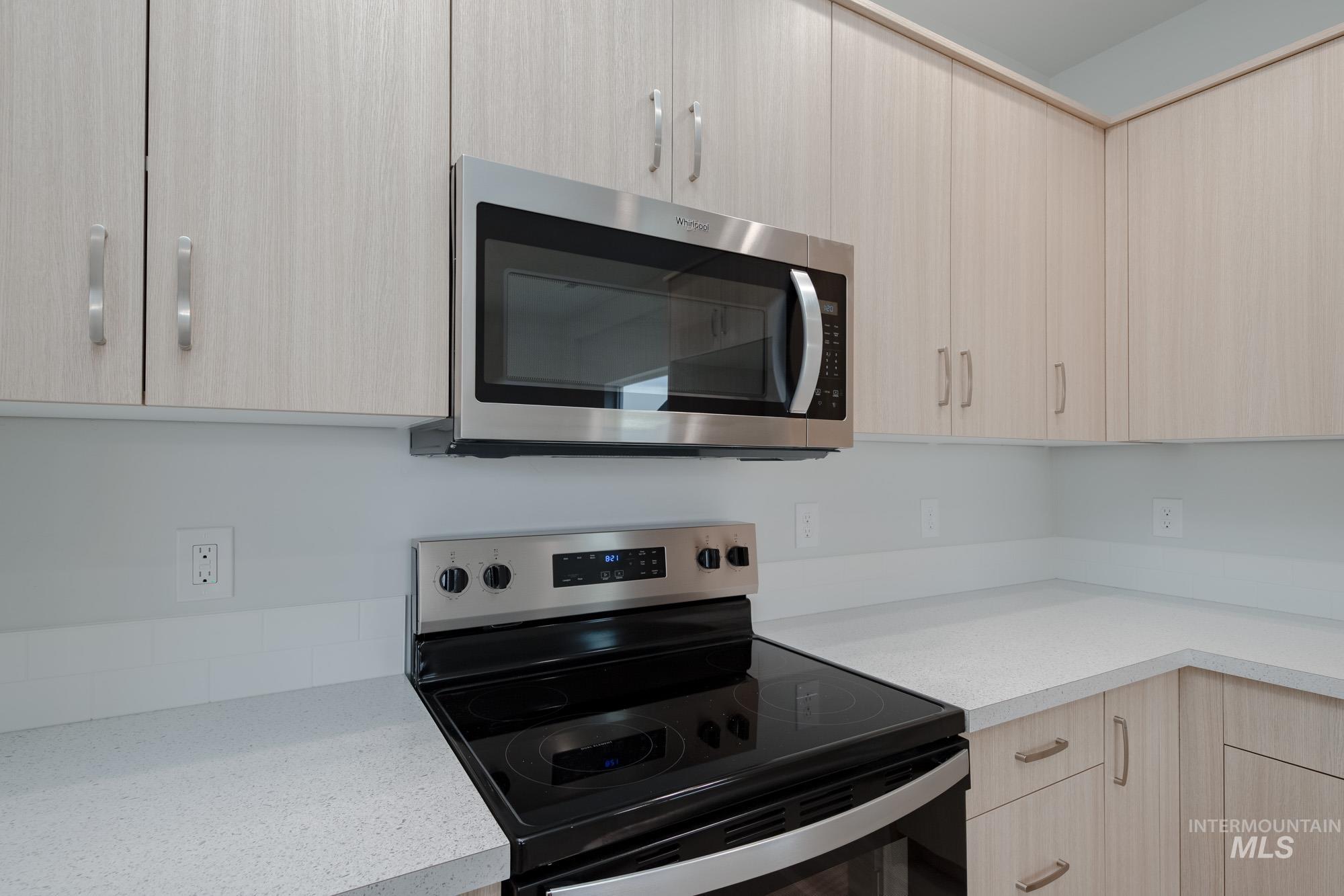 Kitchen featuring light brown cabinetry, appliances with stainless steel finishes, and modern cabinets