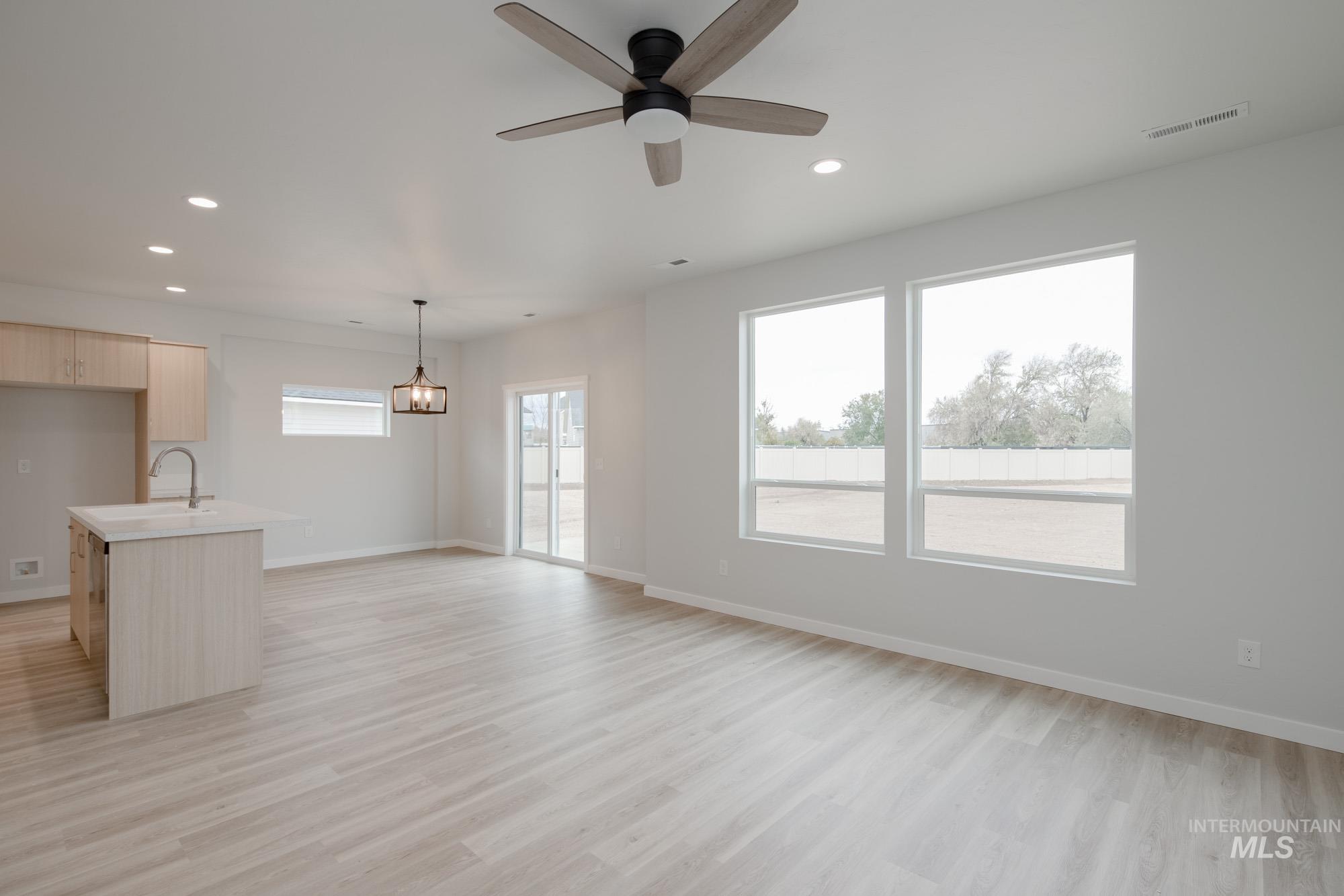 Unfurnished living room with light wood finished floors, recessed lighting, and a ceiling fan