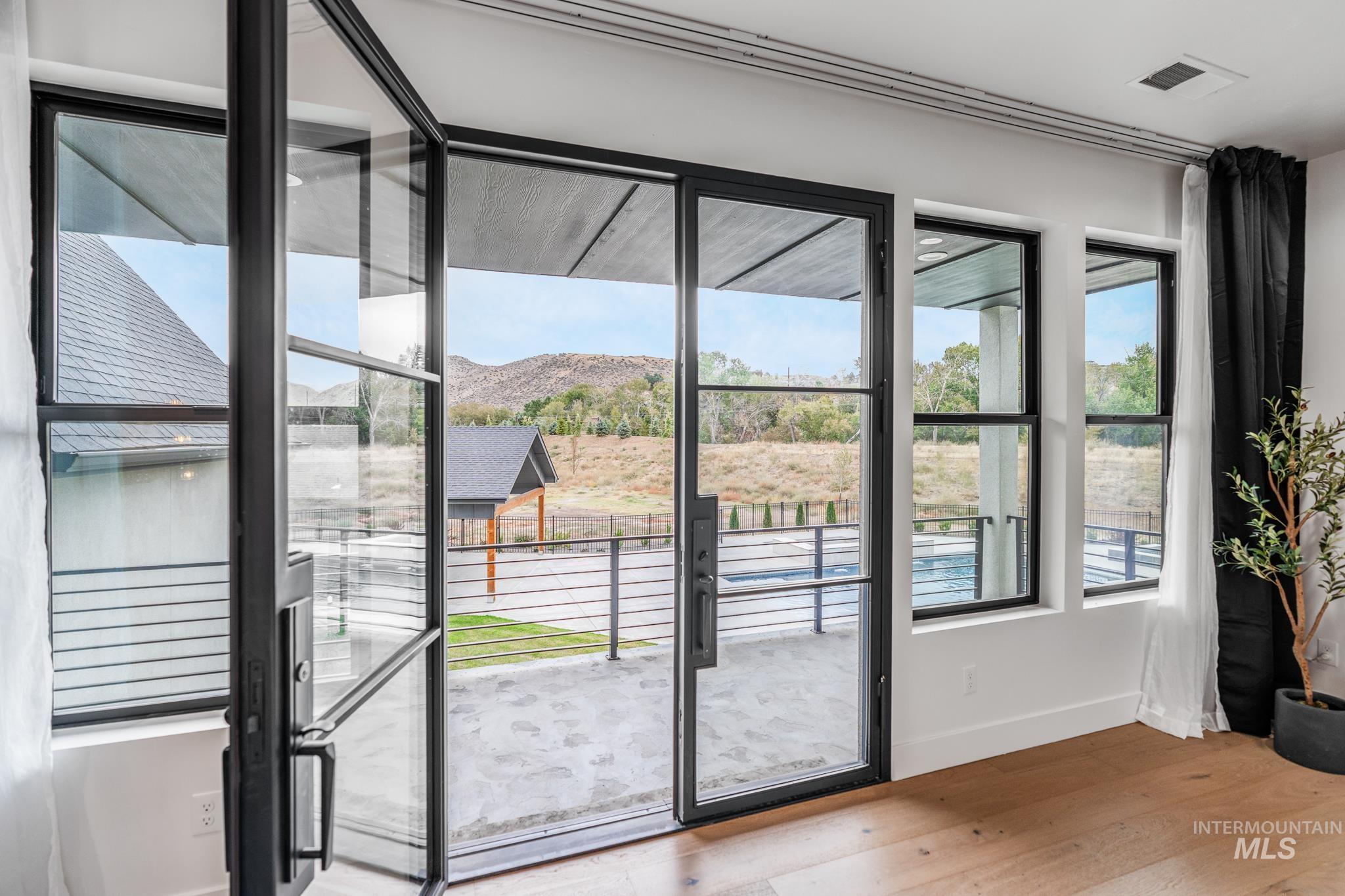 Doorway with a mountain view and wood finished floors