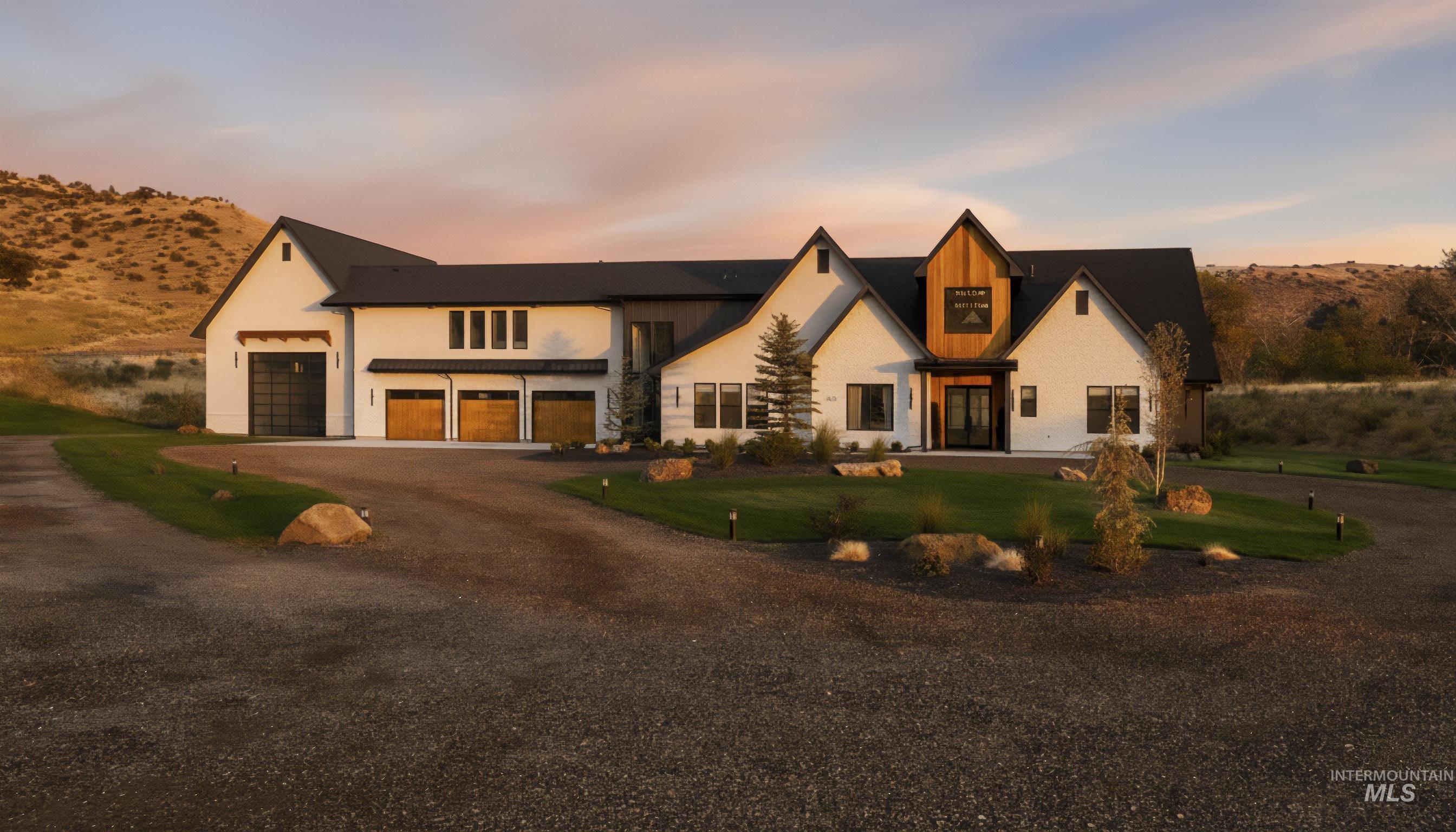 Modern farmhouse featuring driveway, a garage, and stucco siding
