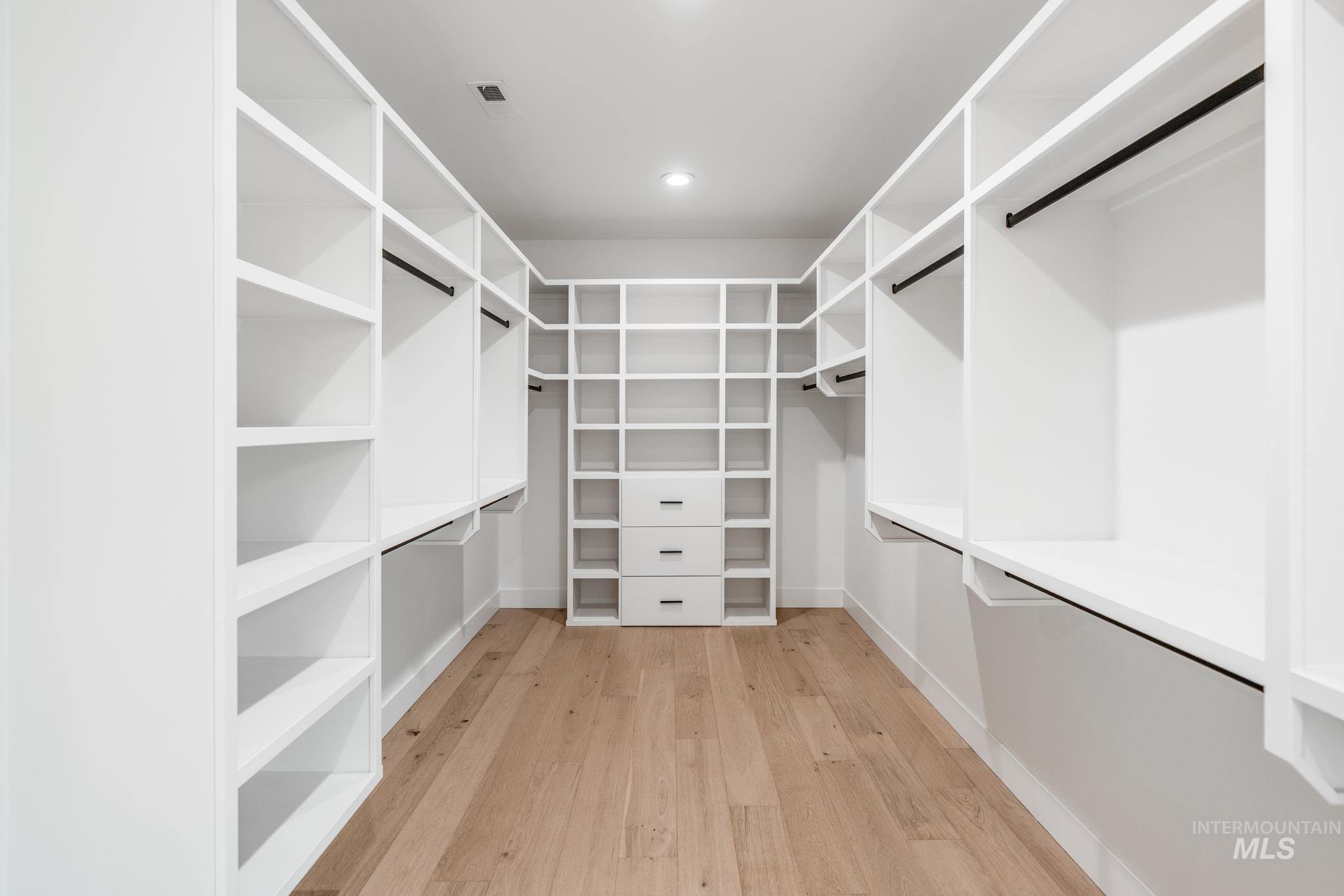 Spacious closet with light wood finished floors