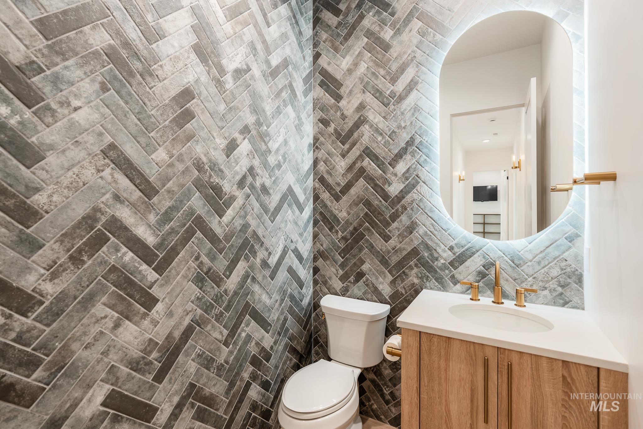 Bathroom with tile walls, vanity, and decorative backsplash