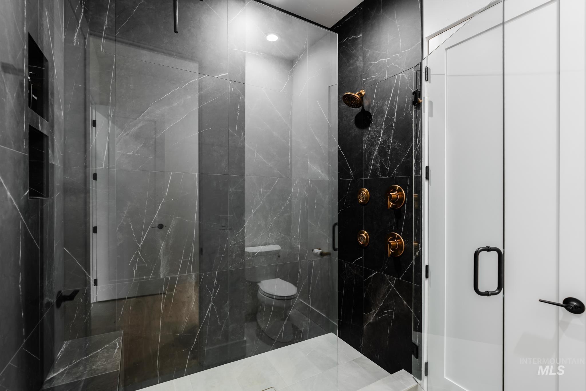 Full bath featuring a marble finish shower