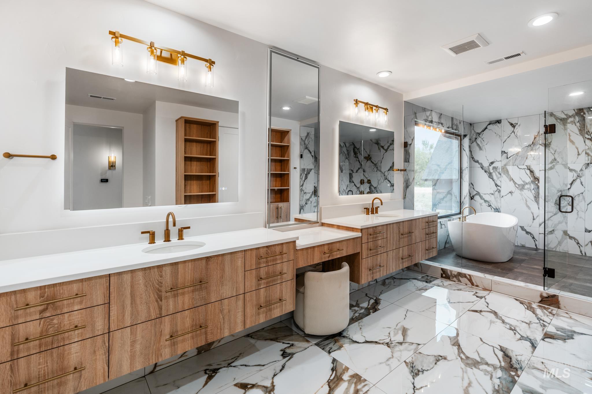 Bathroom with light marble finish flooring, a marble finish shower, a soaking tub, two vanities, and recessed lighting