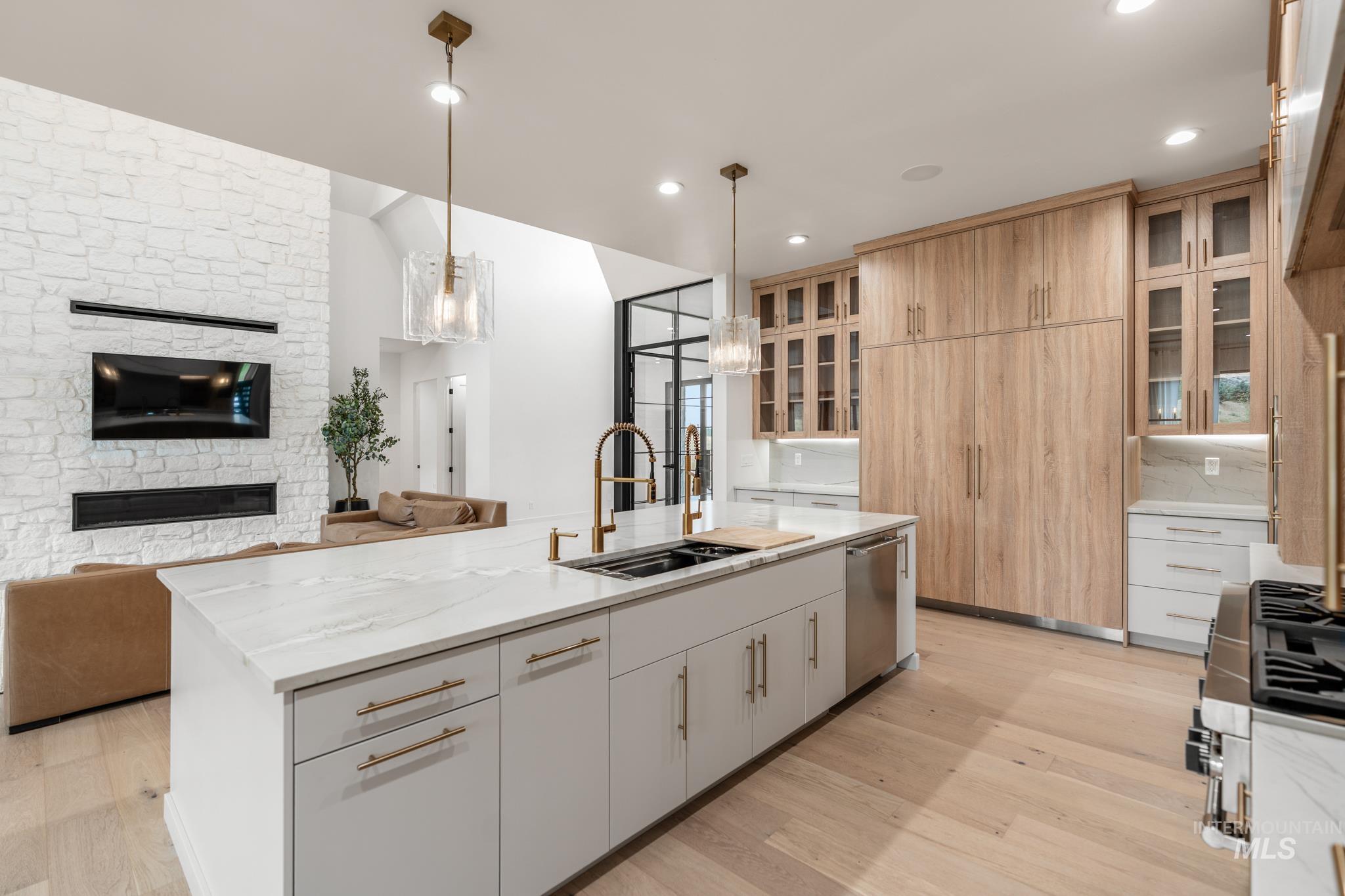 Kitchen featuring hanging light fixtures, light wood-type flooring, a kitchen island with sink, open floor plan, and recessed lighting