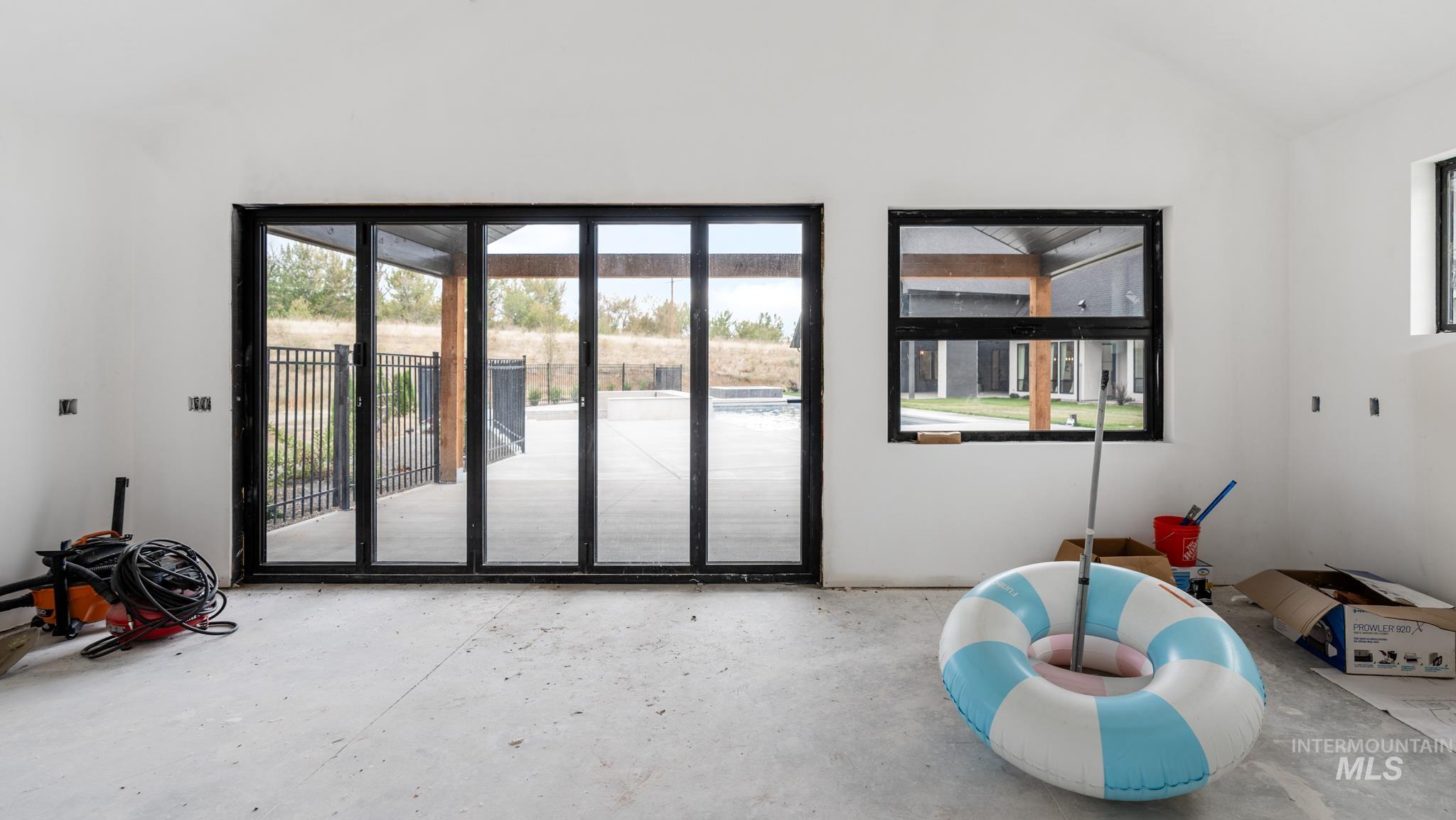 Doorway with concrete floors and lofted ceiling