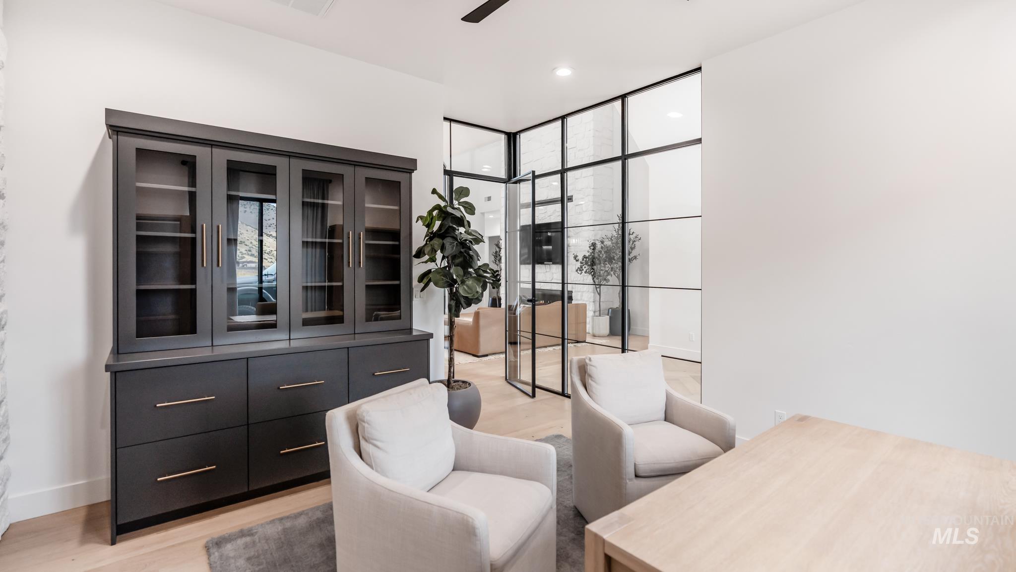 Living area with light wood-style flooring, expansive windows, recessed lighting, and ceiling fan