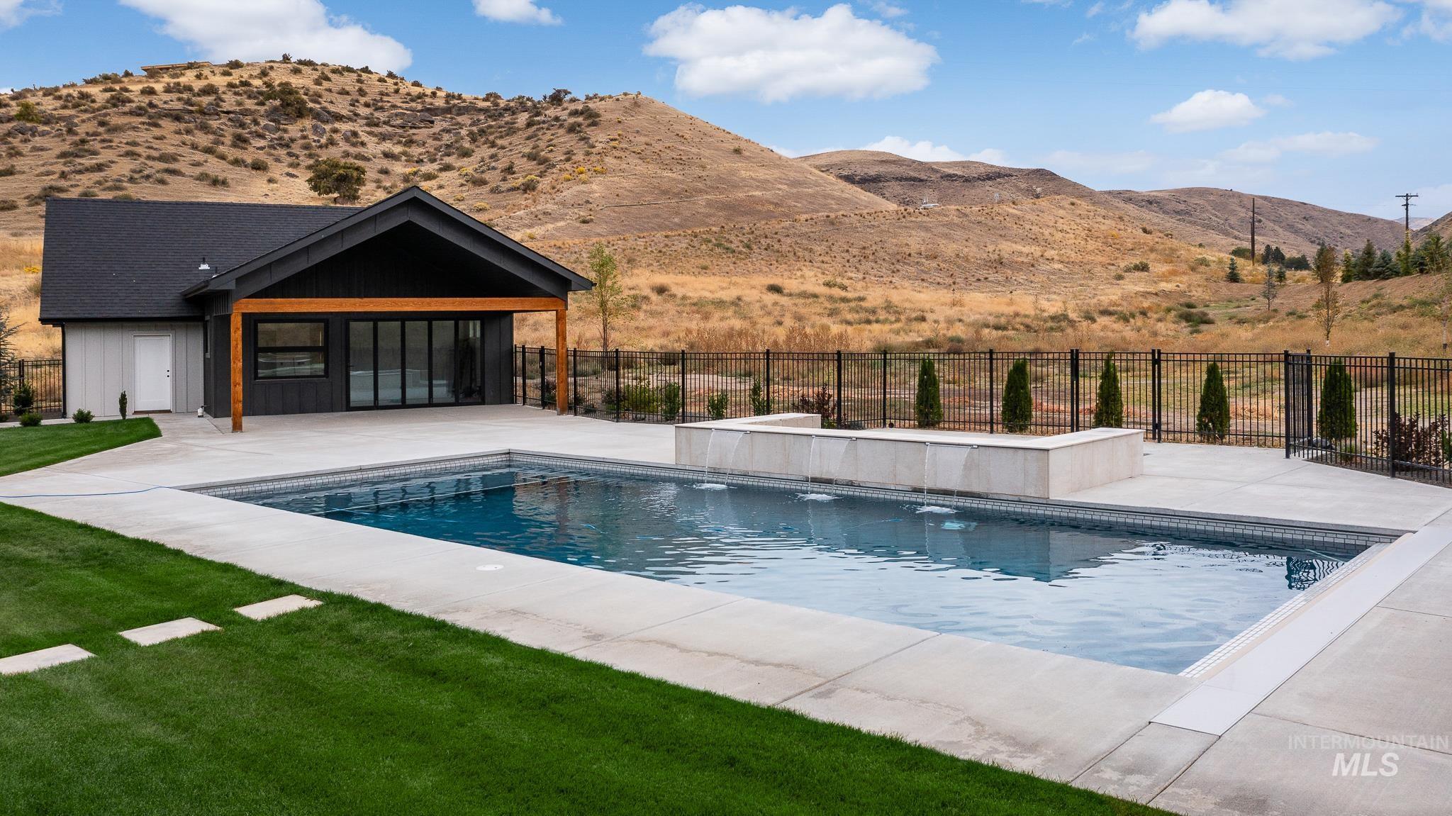 View of swimming pool with a patio and a mountain view