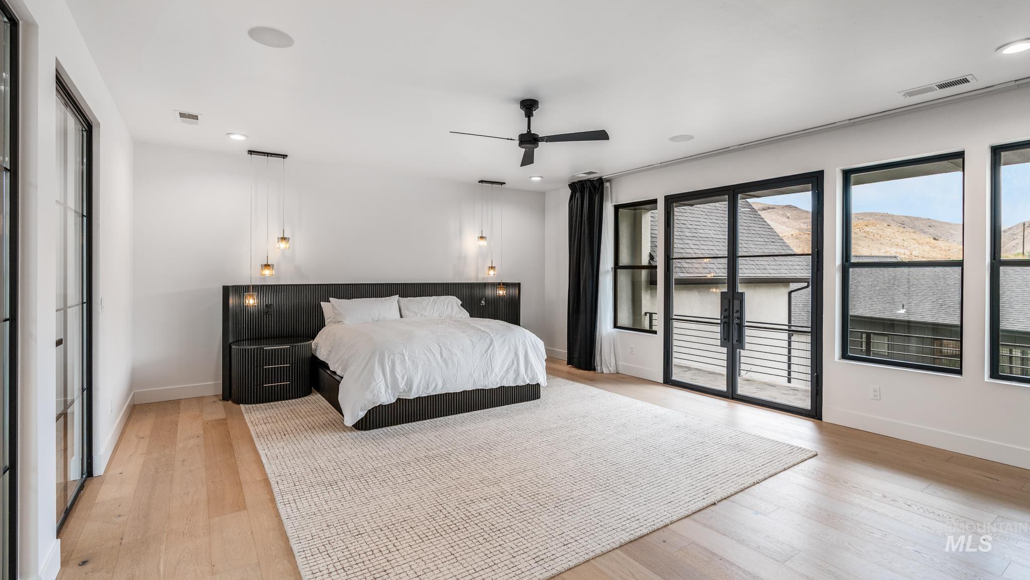 Bedroom featuring light wood-type flooring, access to exterior, recessed lighting, ceiling fan, and a mountain view