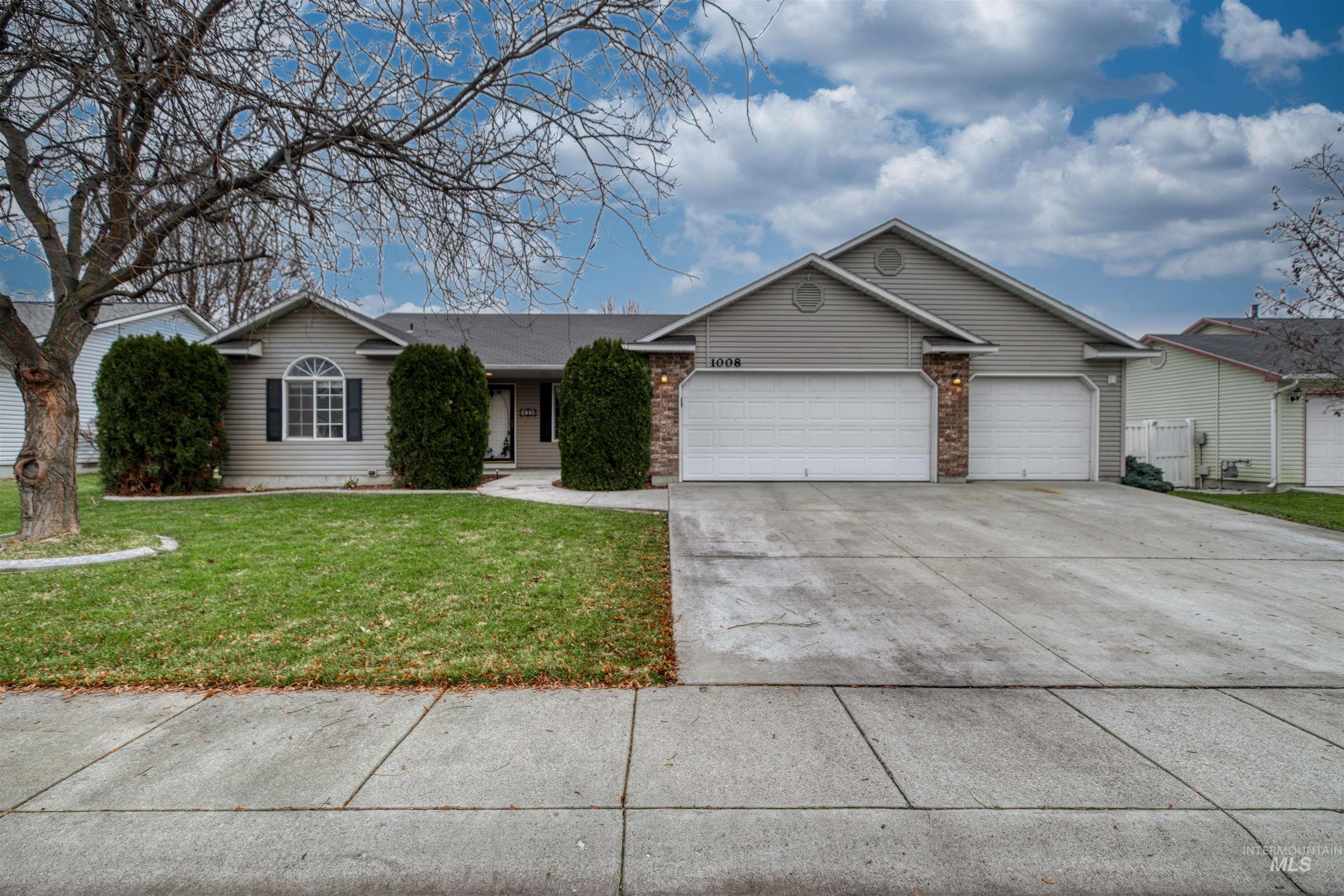 Ranch-style house with concrete driveway, a front yard, brick siding, and a garage