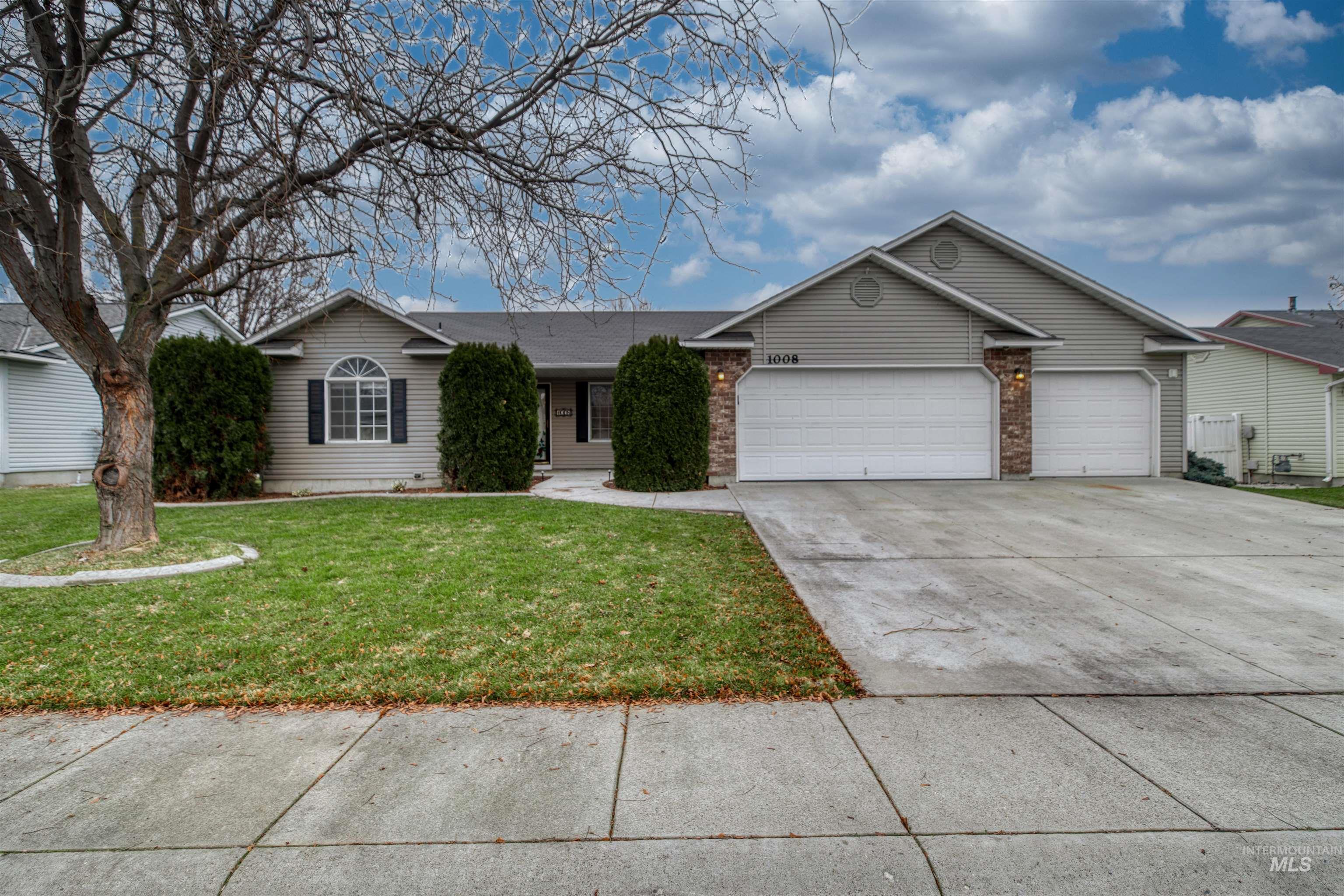 Ranch-style house with a front yard, concrete driveway, a garage, and brick siding