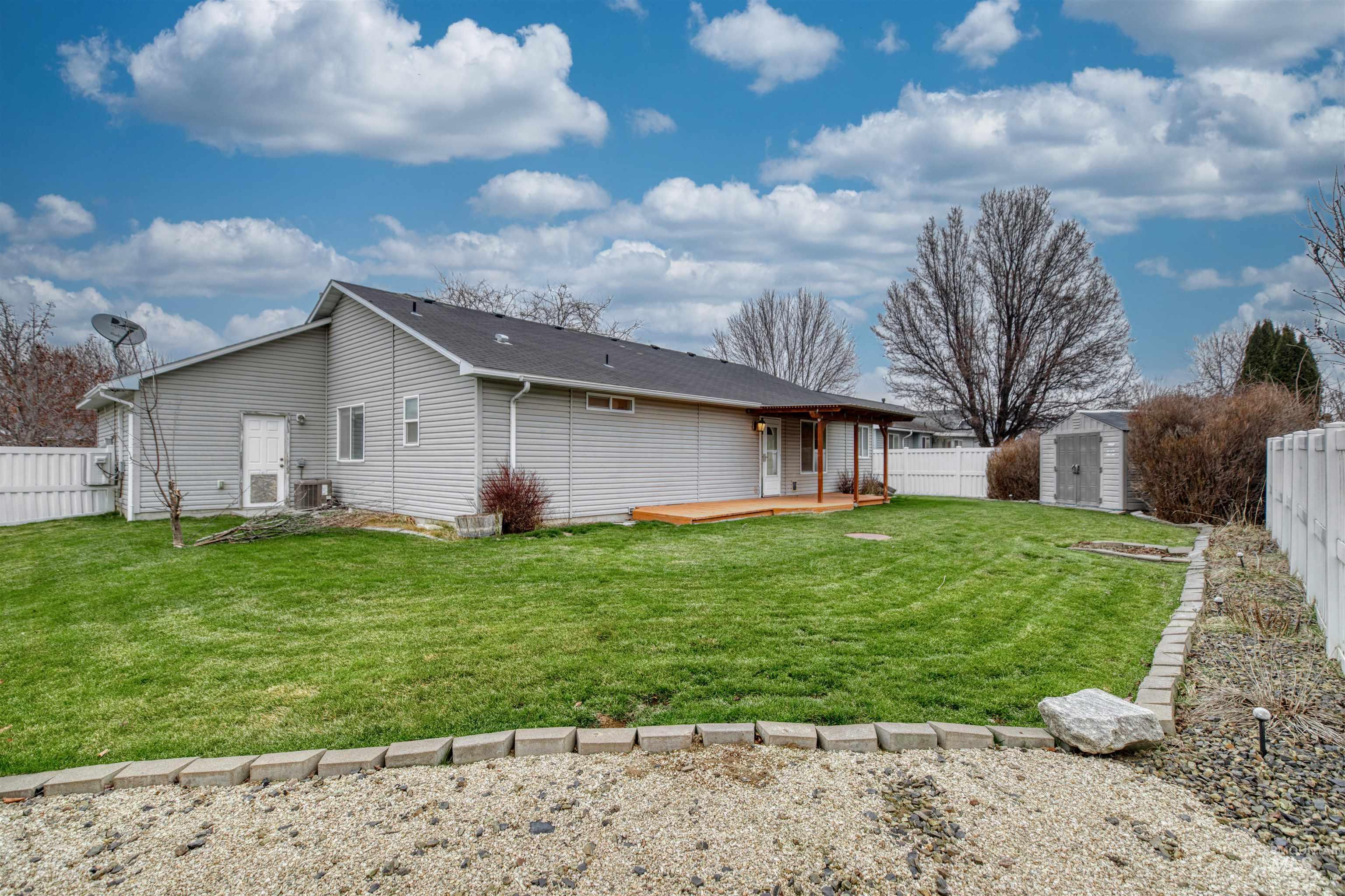 Rear view of house featuring a fenced backyard, a storage unit, and a deck
