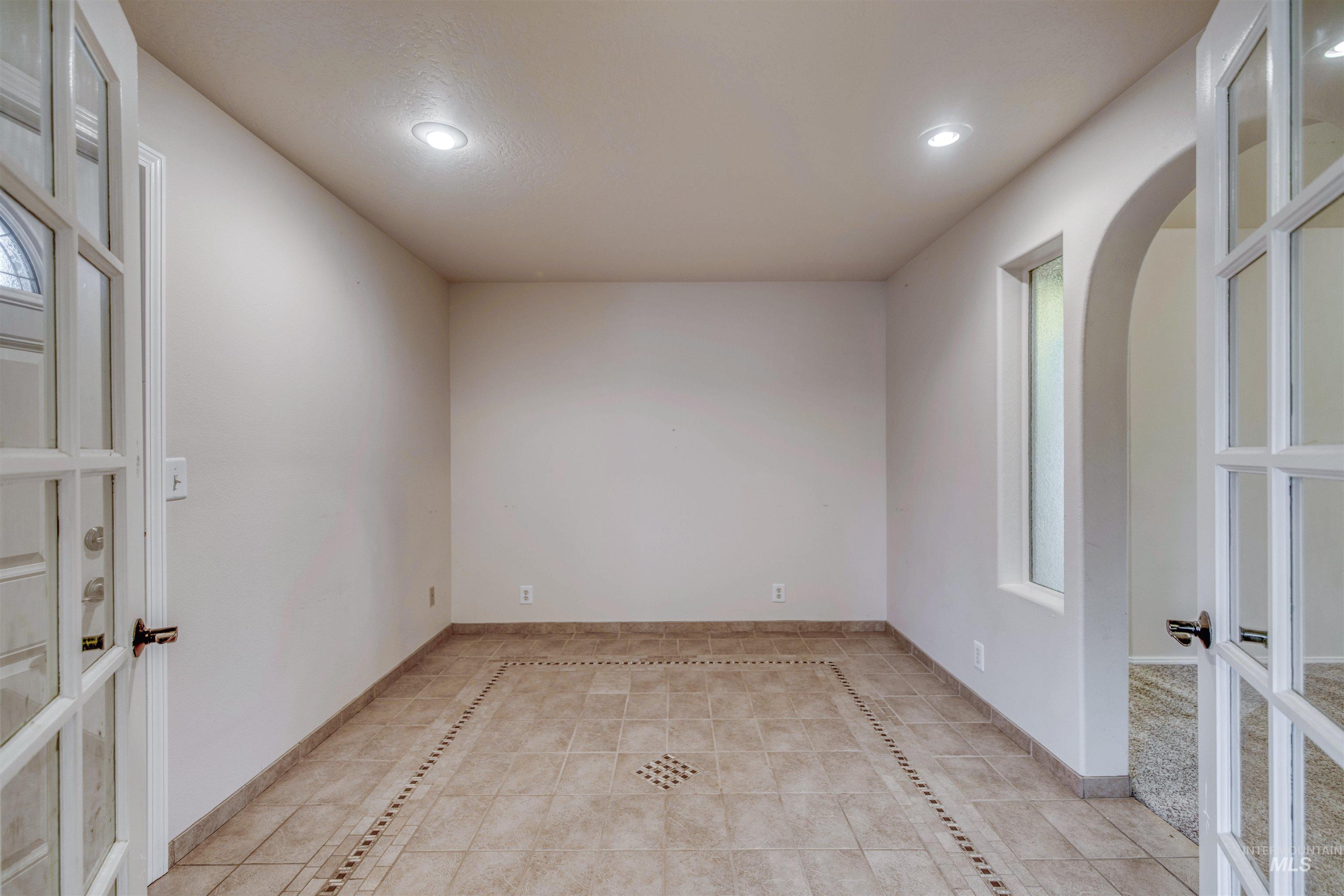 Spare room featuring french doors, light tile patterned floors, recessed lighting, and inlaid floor details