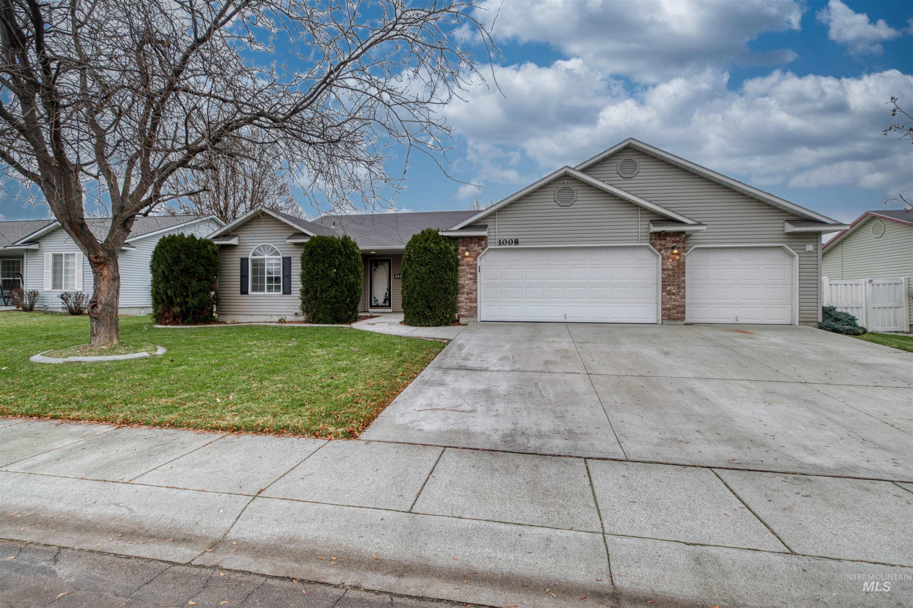 Ranch-style house with concrete driveway, a front yard, a garage, and brick siding