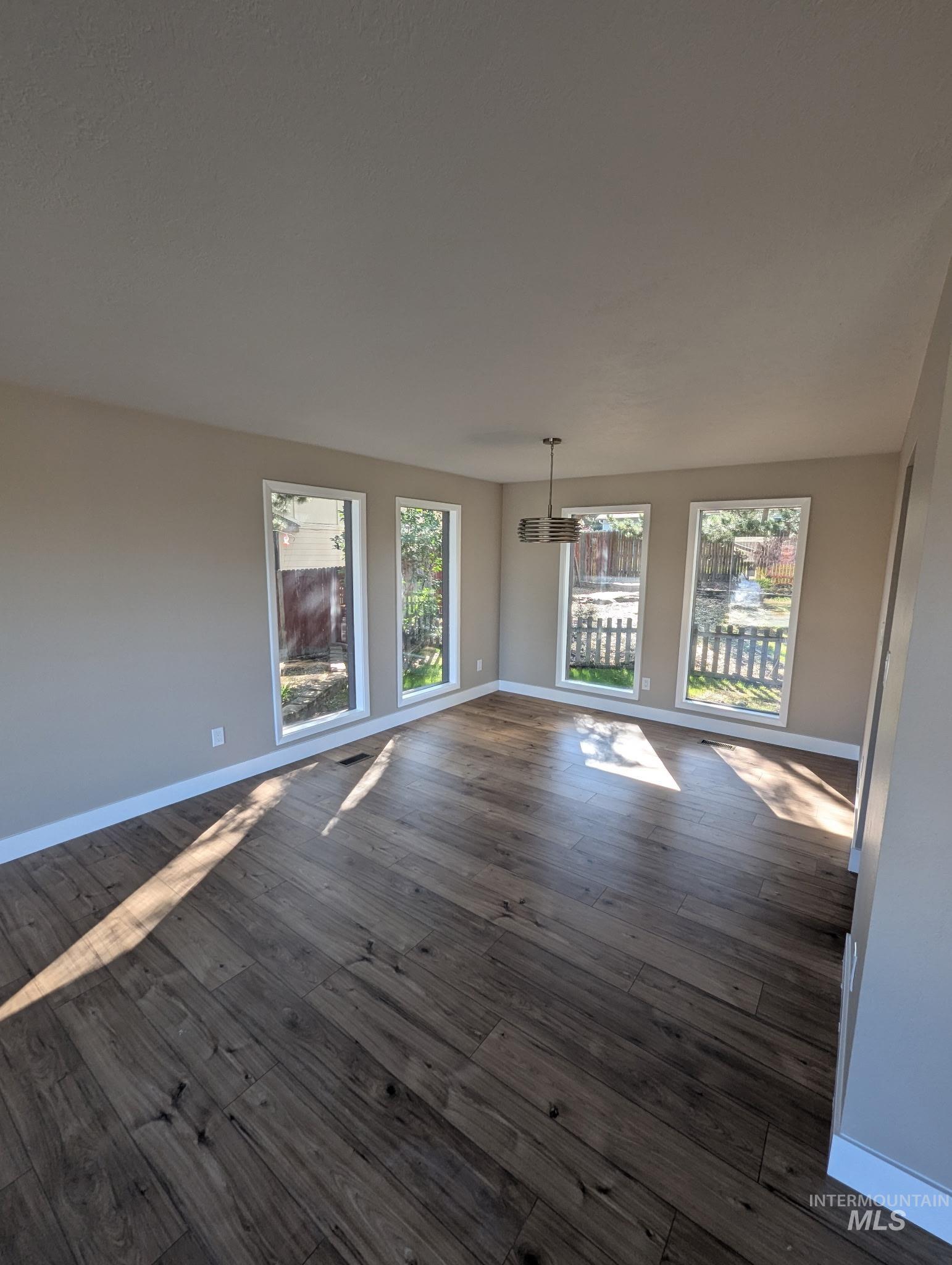Unfurnished living room with baseboards and dark wood finished floors