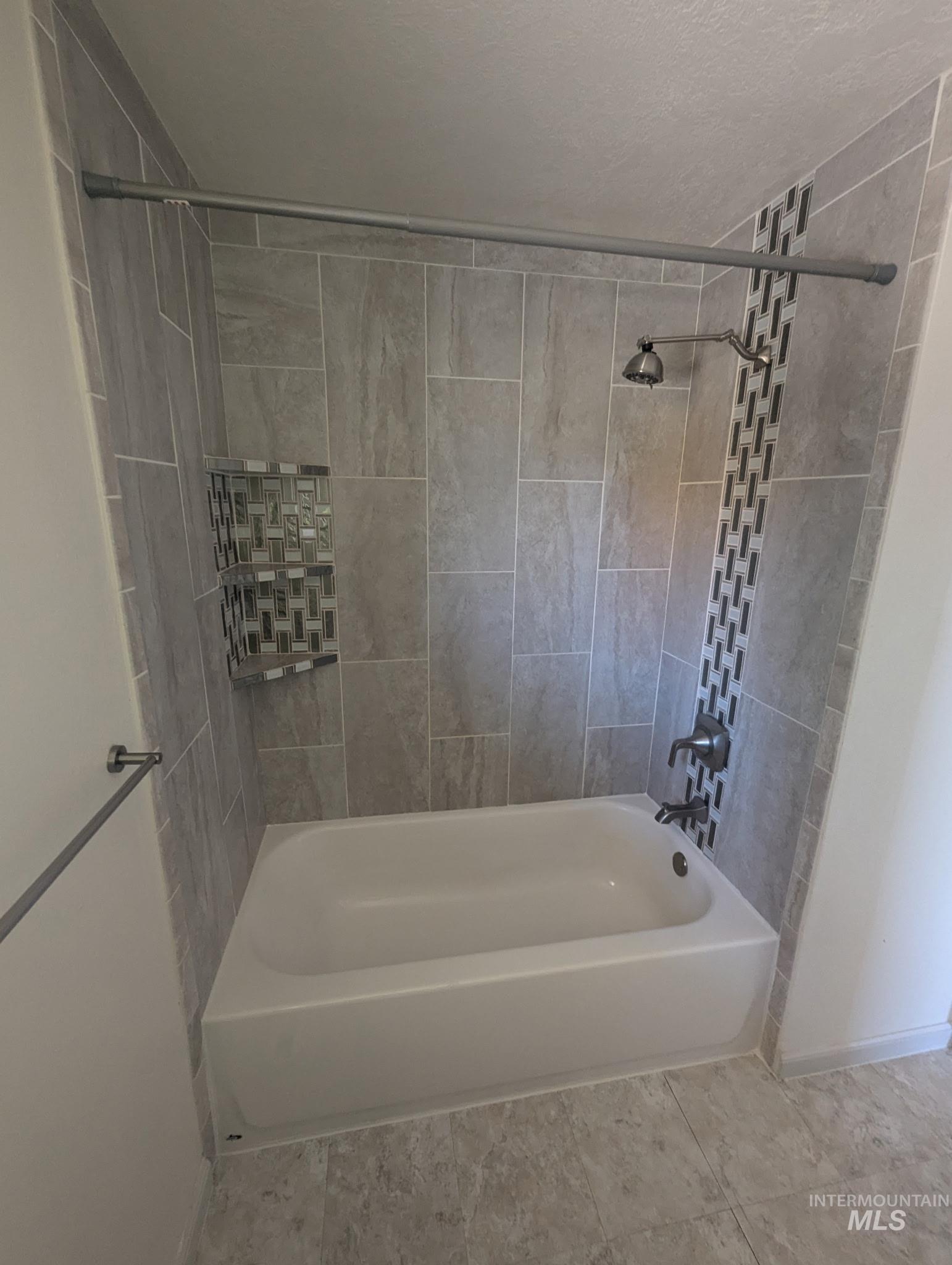 Bathroom featuring tub / shower combination and tile patterned flooring