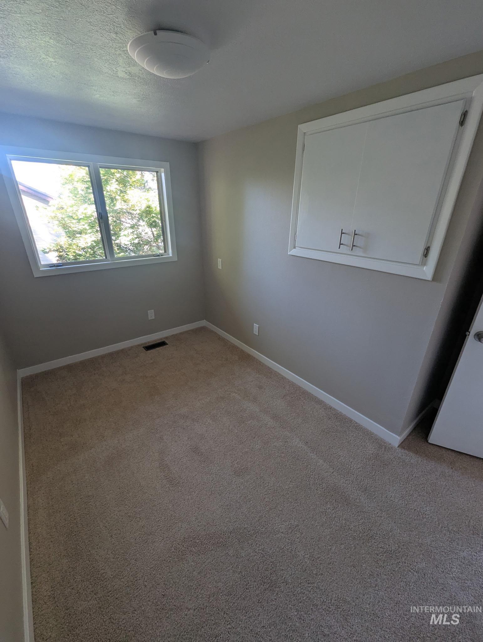 Unfurnished bedroom with carpet flooring and a textured ceiling