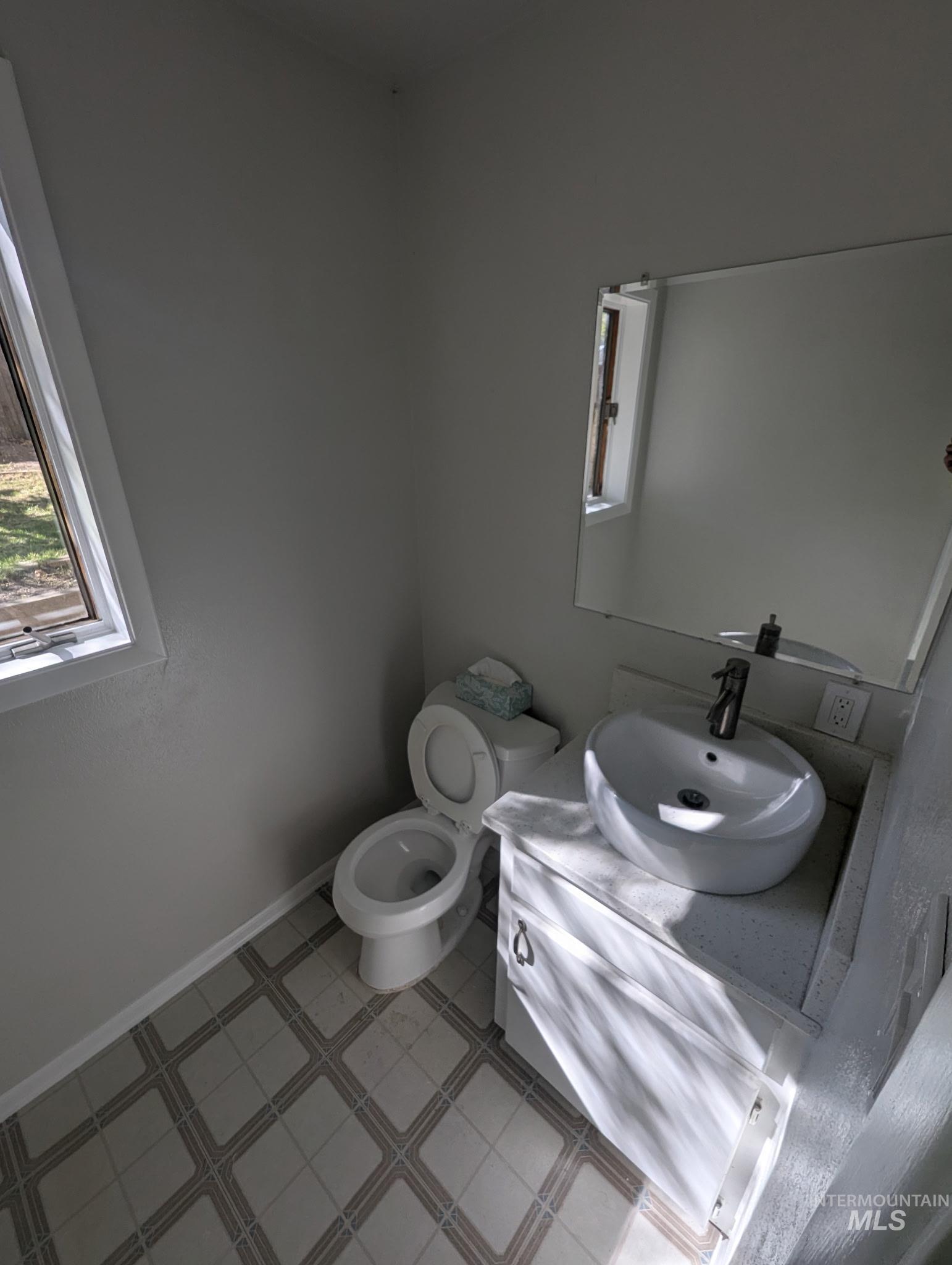 Half bathroom featuring vanity and baseboards