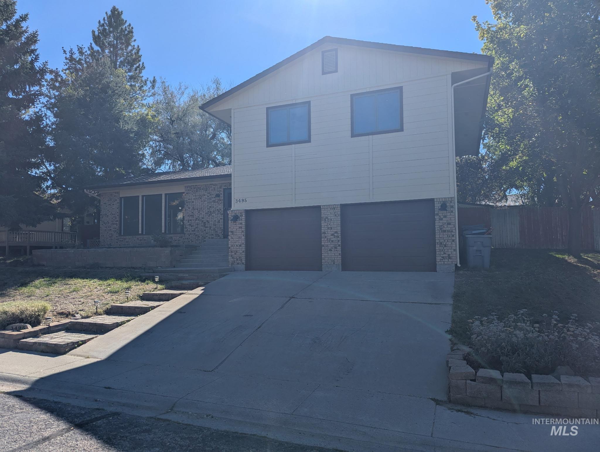 View of front of home with brick siding, concrete driveway, and a garage