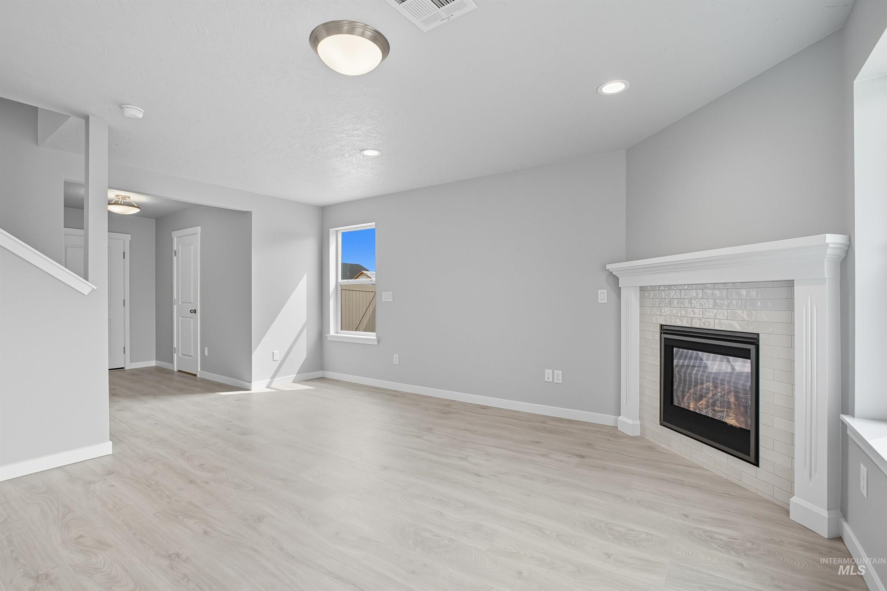 Living area featuring a corner fireplace with white subway tile surround and a classic white mantel