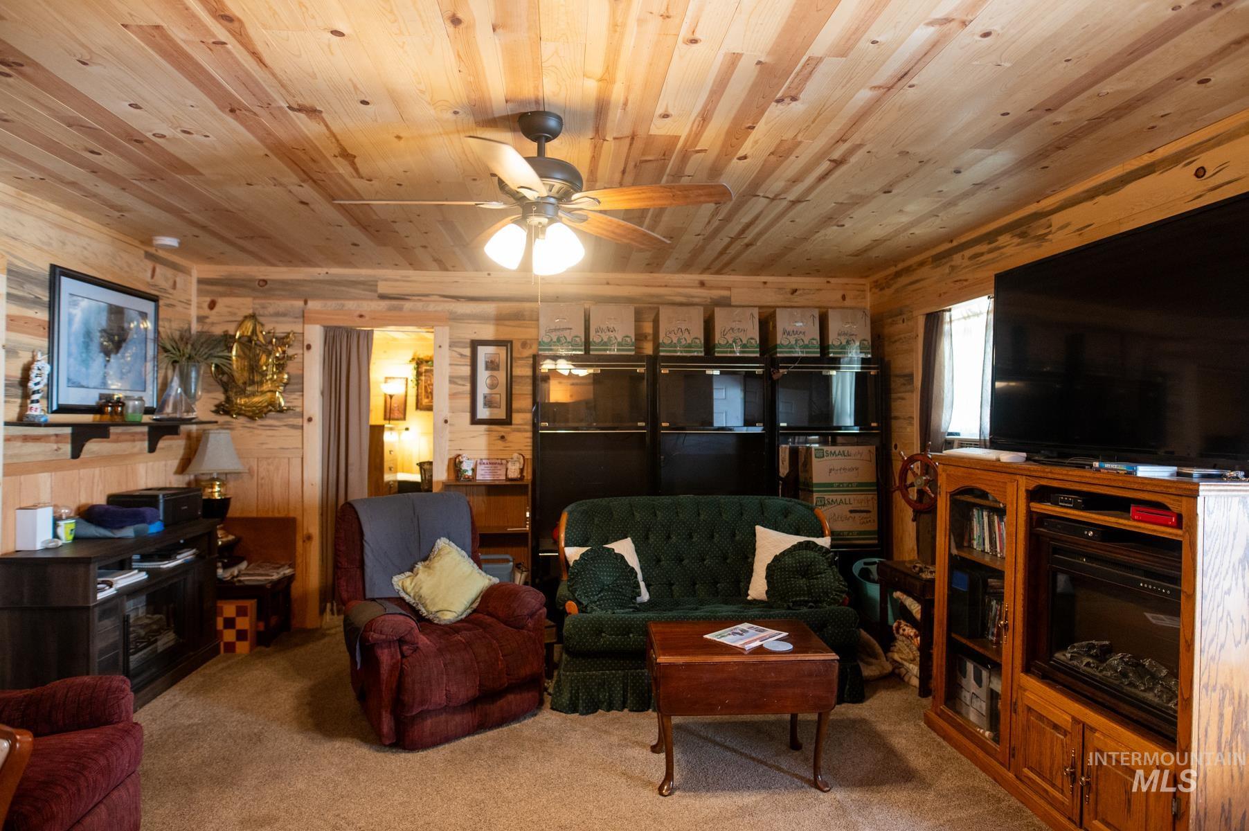 Living area featuring wood-paneled walls and ceiling