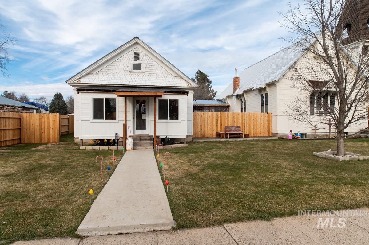 Bungalow-style house featuring a fenced backyard and entry steps