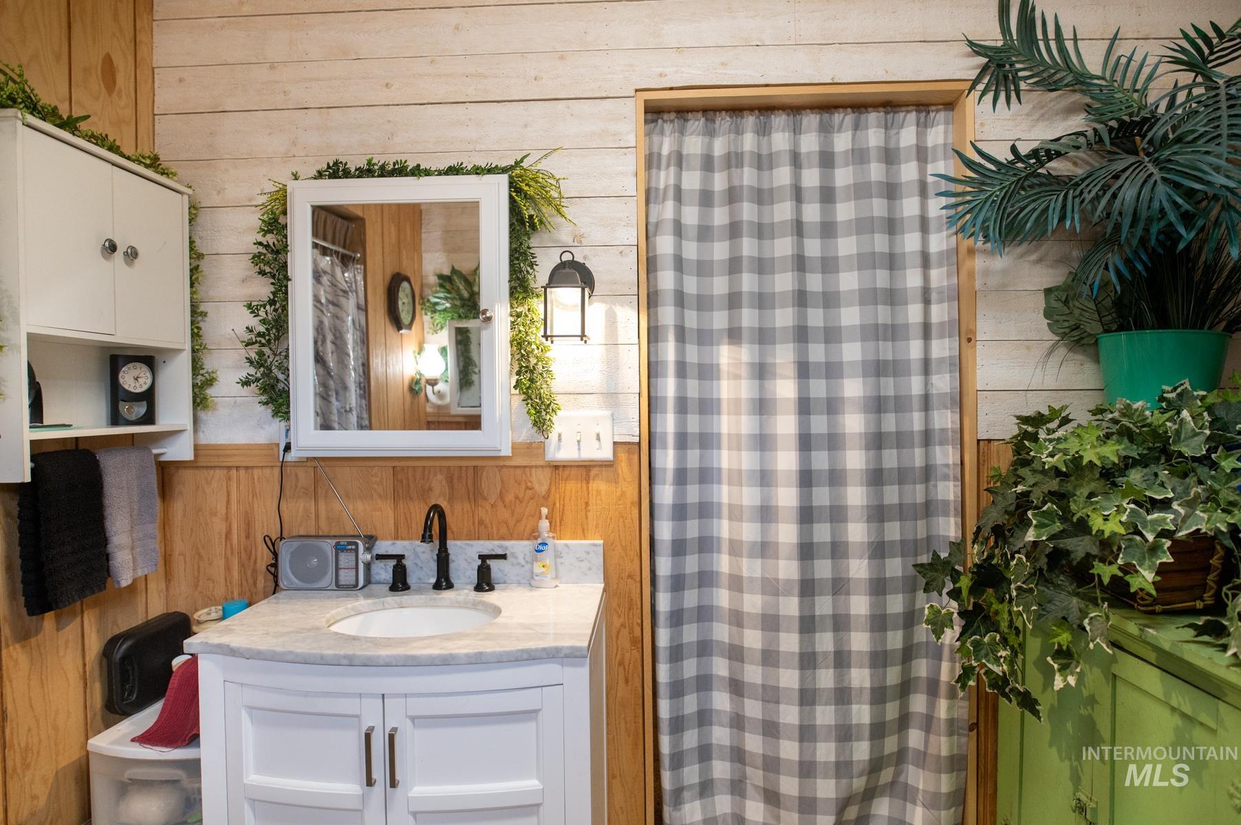 Bathroom vanity featuring a white cabinet base, undermount sink, and stone countertop