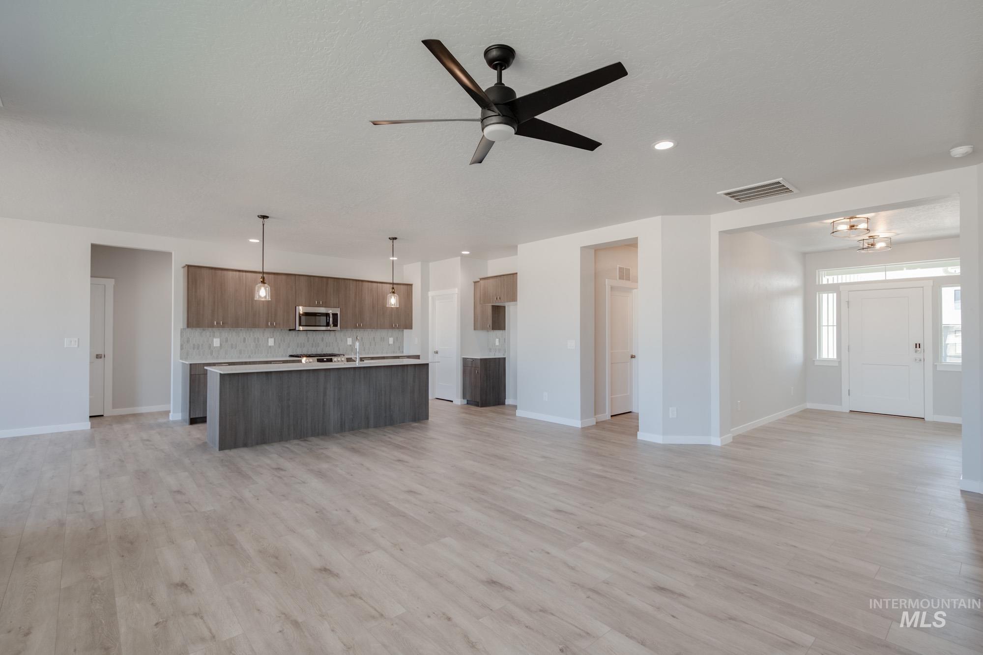 Unfurnished living room with light wood-style flooring, ceiling fan, and recessed lighting