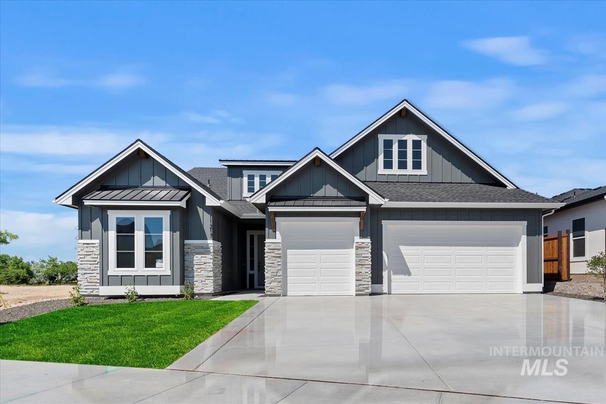 Craftsman-style house with board and batten siding, concrete driveway, a front lawn, and a shingled roof