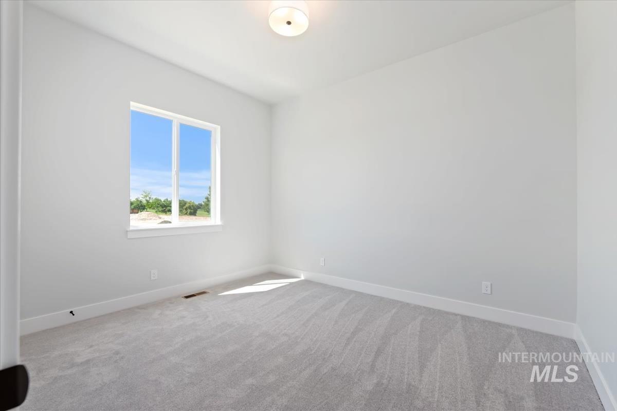 Carpeted spare room with baseboards