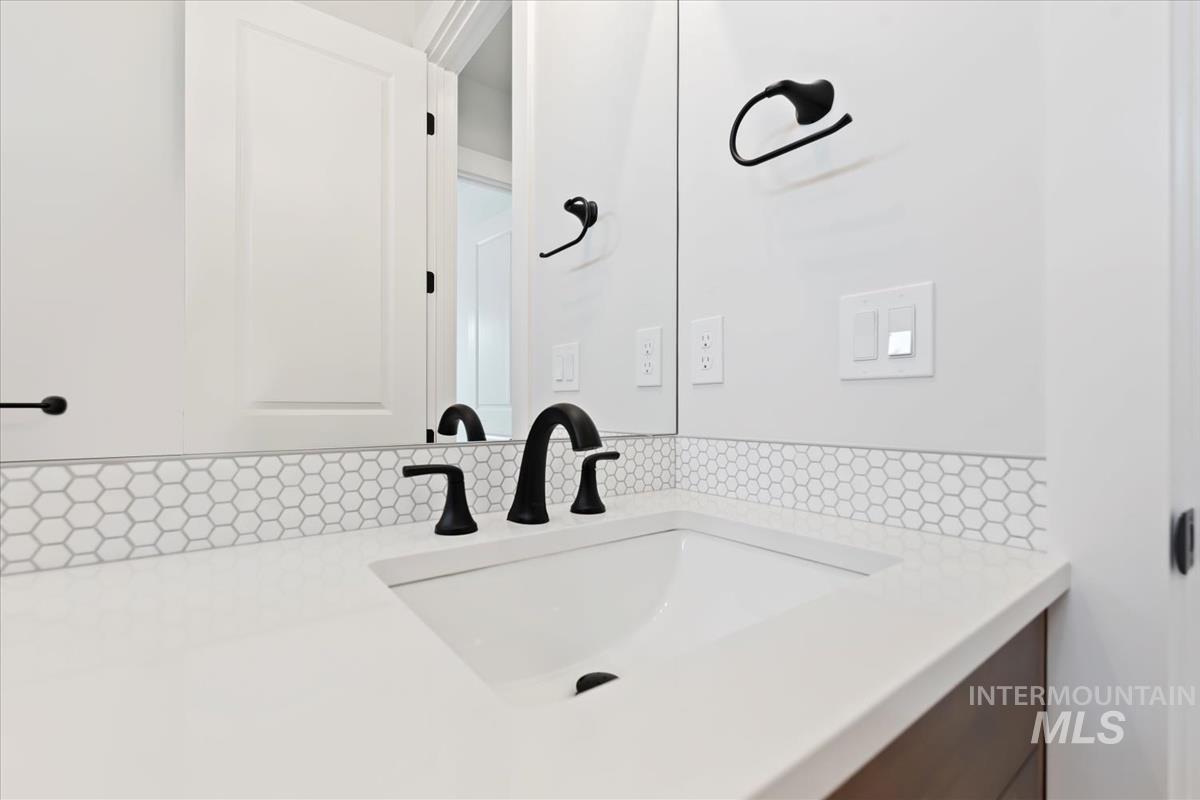 Bathroom with vanity and decorative backsplash