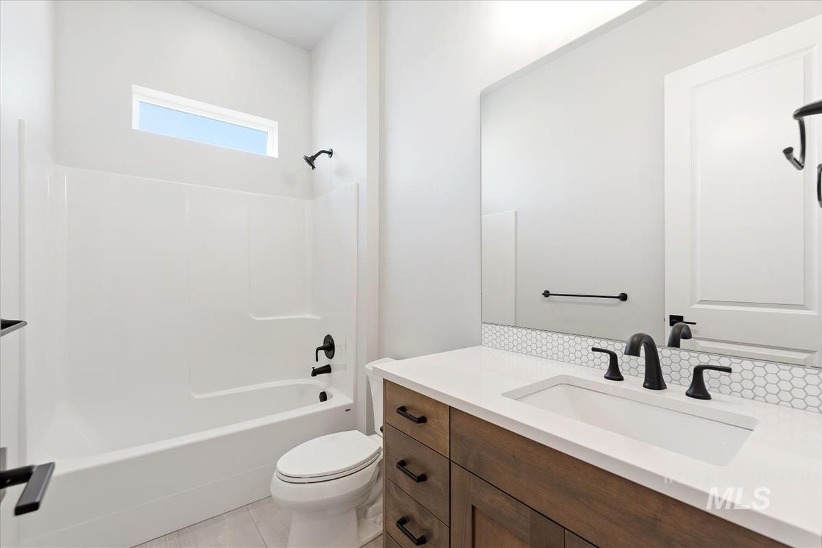 Full bathroom with shower / washtub combination, vanity, and light tile patterned floors