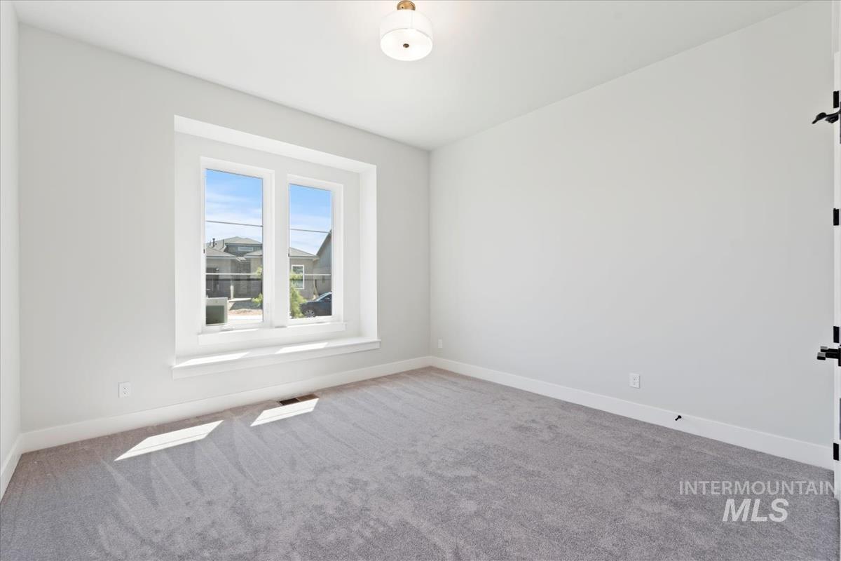 Carpeted spare room with baseboards